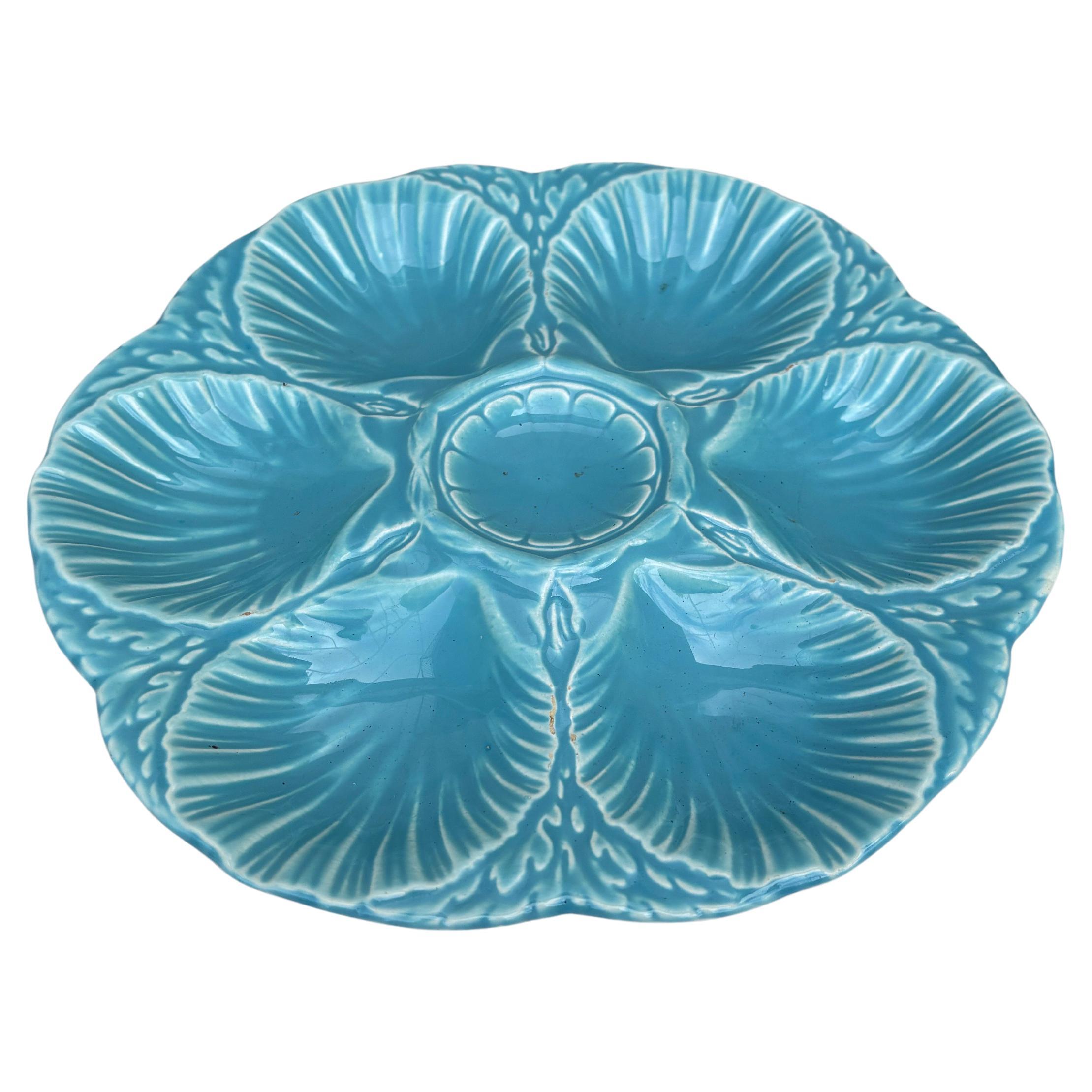 Assiette à huîtres en majolique française aqua turquoise signée Sarreguemines Majolica, vers 1900.
6 coquilles et un espace pour le citron au centre.