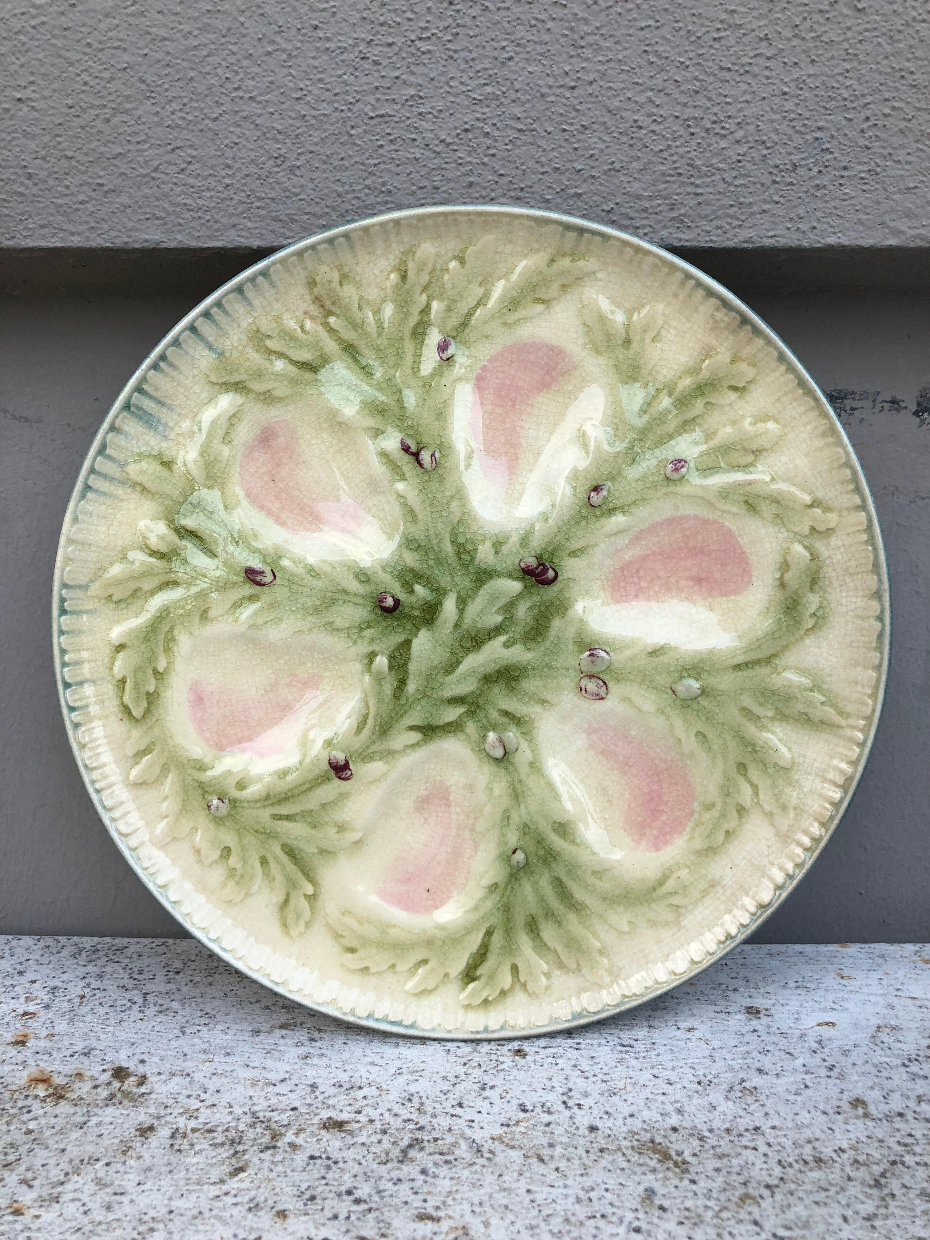 French Majolica oyster plate signed Hippolyte Boulenger Choisy-le-Roi. The six pink wells are surrounded by green seaweeds.