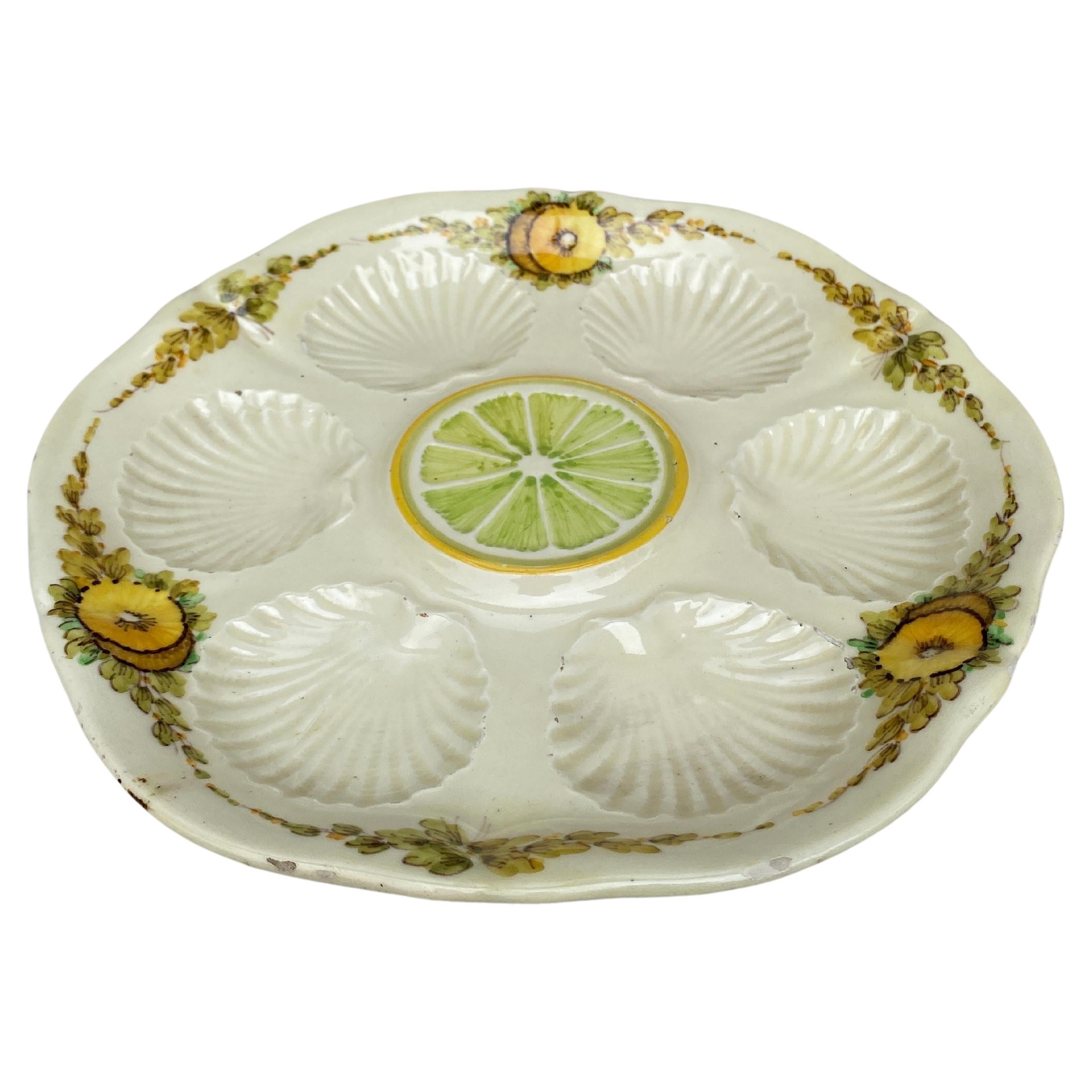 Unusual French Majolica oyster plate with yellow flowers and lemon on the center, circa 1890.
