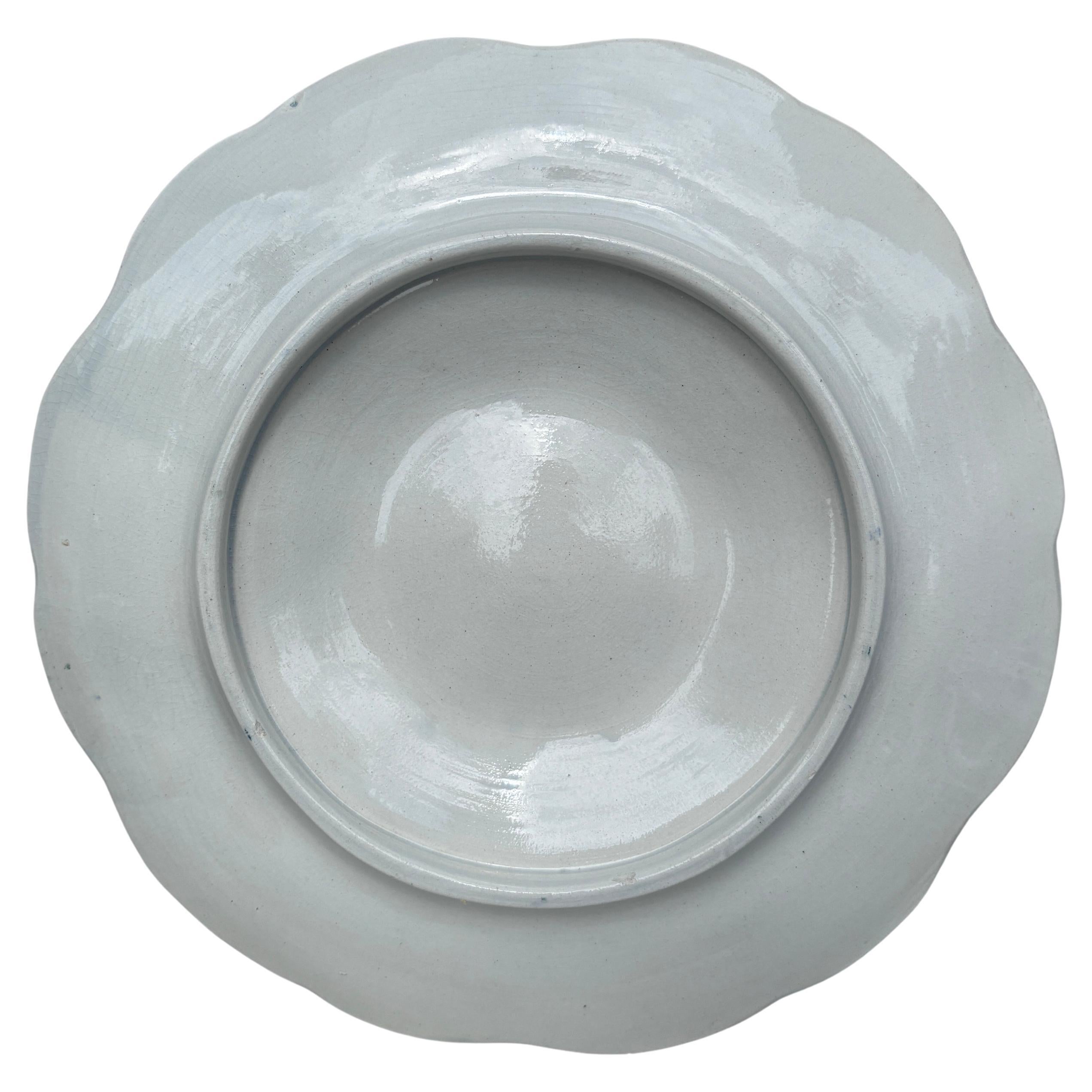 Assiette en majolique avec étoile de mer orange à six puits bleu et blanc entourée d'algues vertes Digoin (Est de la France), vers 1900.