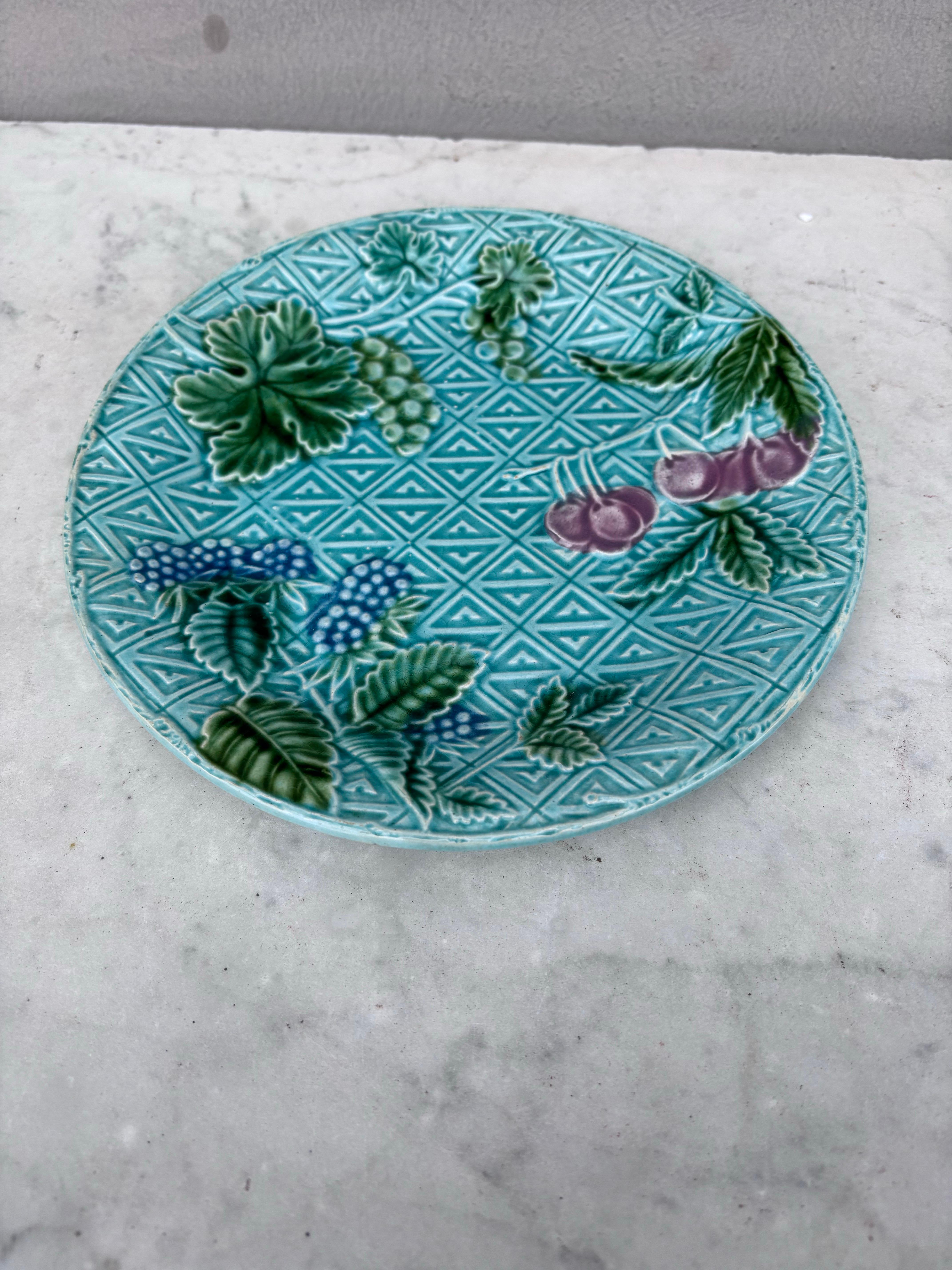 Grazioso piatto francese in maiolica con frutta (more, ciliegie, frutti di bosco) firmato Salins, circa 1890.