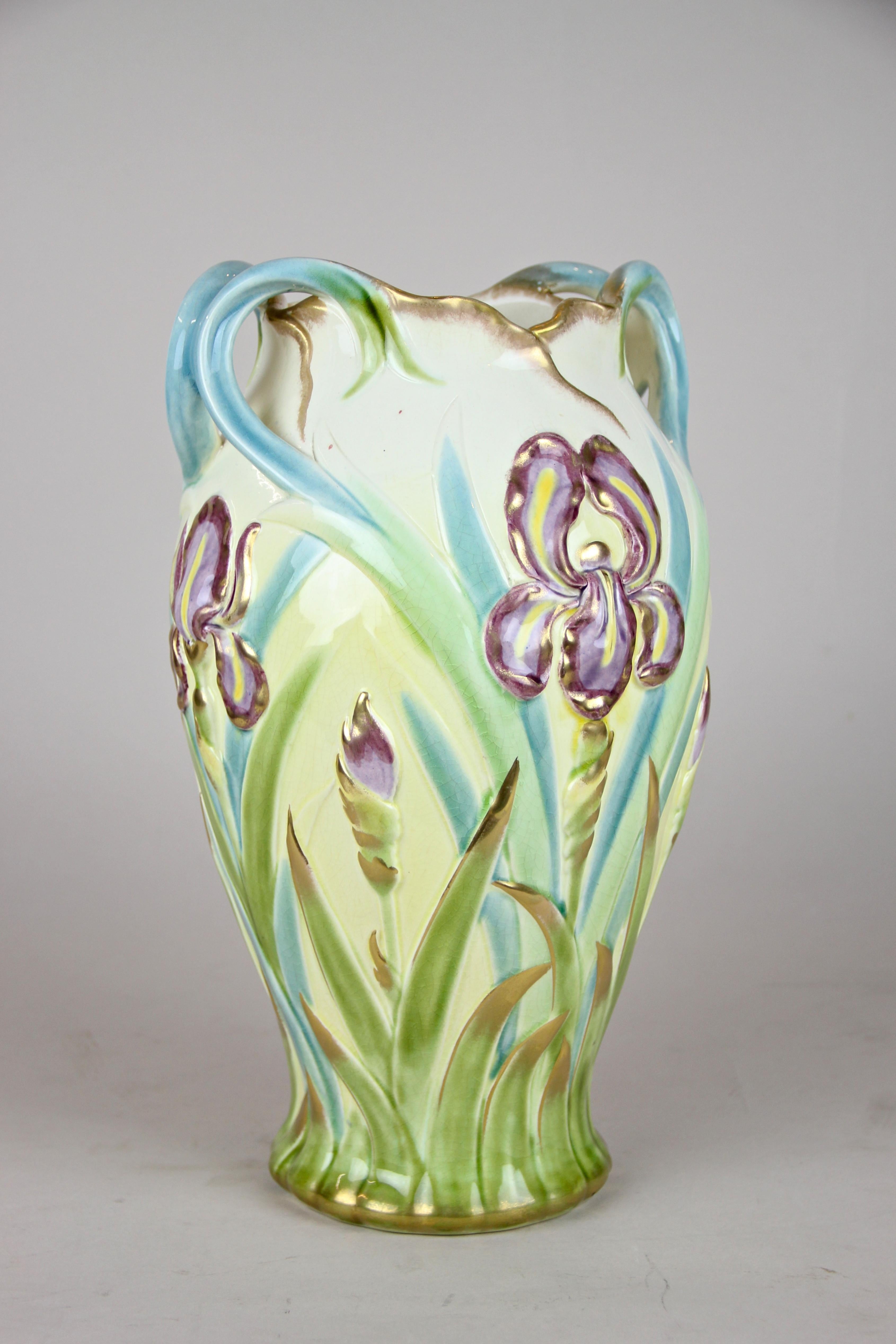 Charming French Majolica vase by Sarreguemines out of France, circa 1915. This early 20th century vase shows an absolute lovely colored floral design. The bulbous body is adorned by depictions of grass and beautiful violets, highlighted by gilt