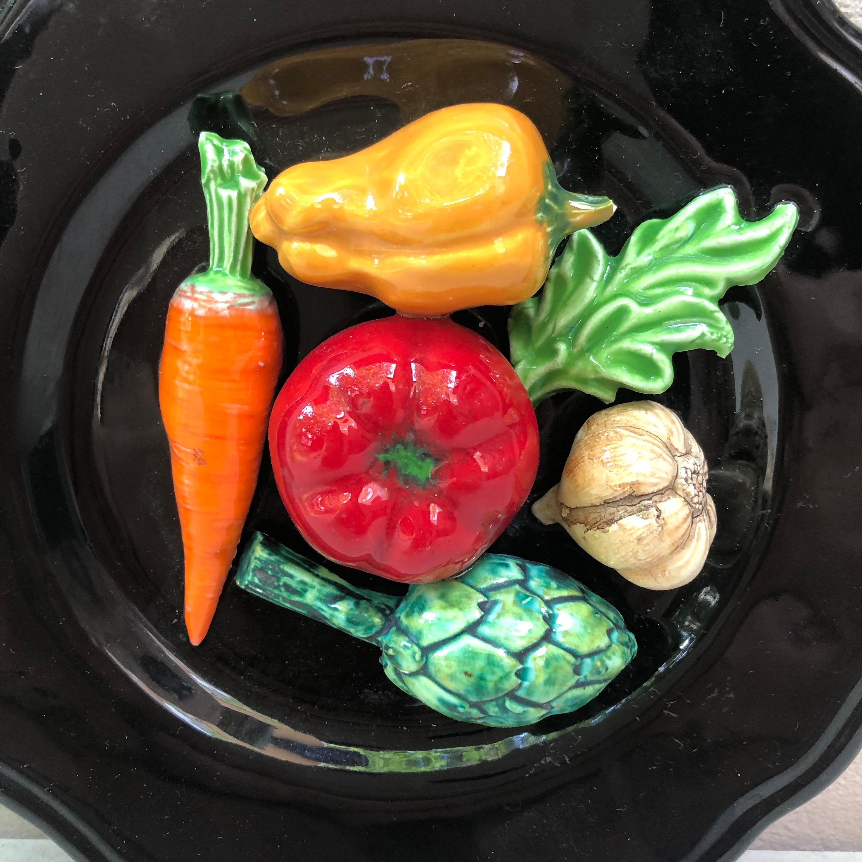 French Majolica vegetable wall platter Vallauris, circa 1950.
On a black background it's a trompe l'oeil platter with tomatoe, artichoke, garlic, carrot, pepper.