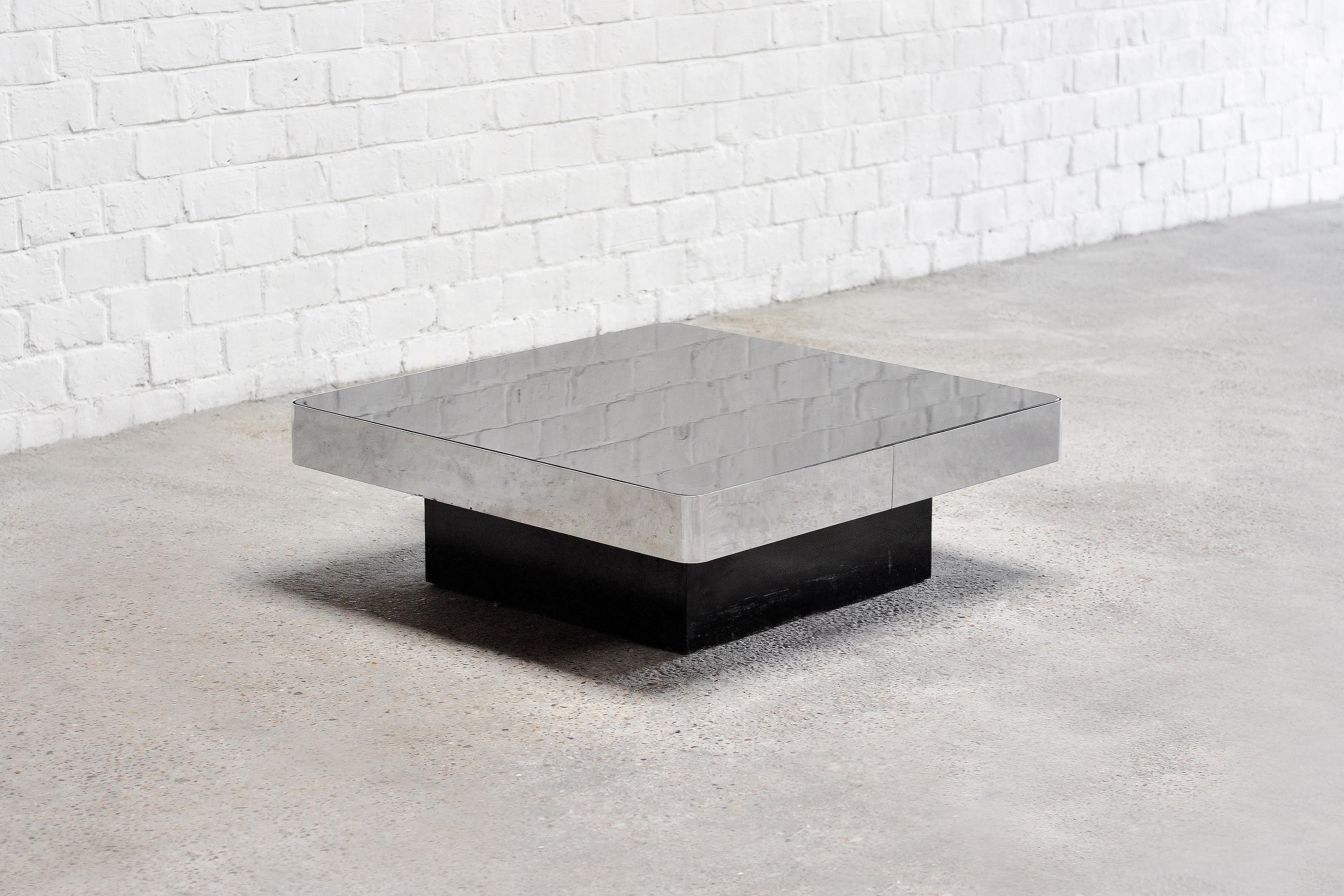 A 1970's coffee table designed by François Monnet, model 'Mangouste'. Produced by Kappa France. This model feautures a black lacquered wooden base, brushed steel band and and a smoked mirror glass. A very sophisticated and minimalistic design of