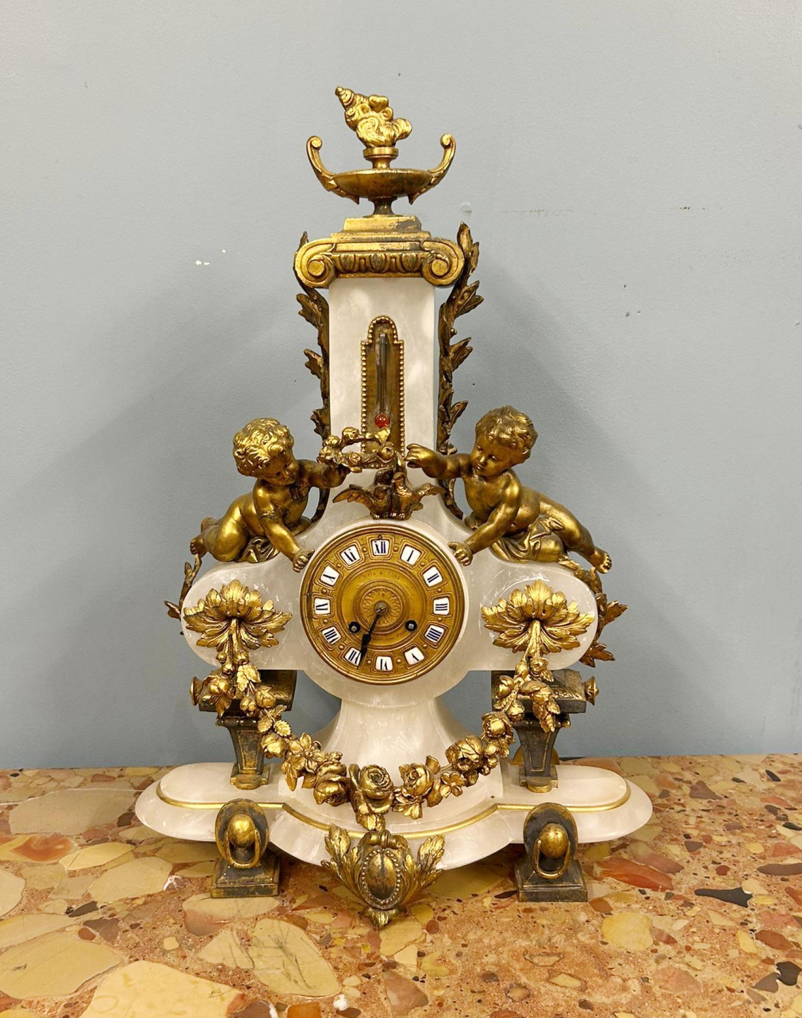 You are viewing an ornate French Louis XV mantel clock
Crafted from alabaster marble with ormolu fixtures including the cherubs (putti)
Fully working with 8 day movement

Circa 1880 Enamel numerals on face and central thermometer
Bought from a