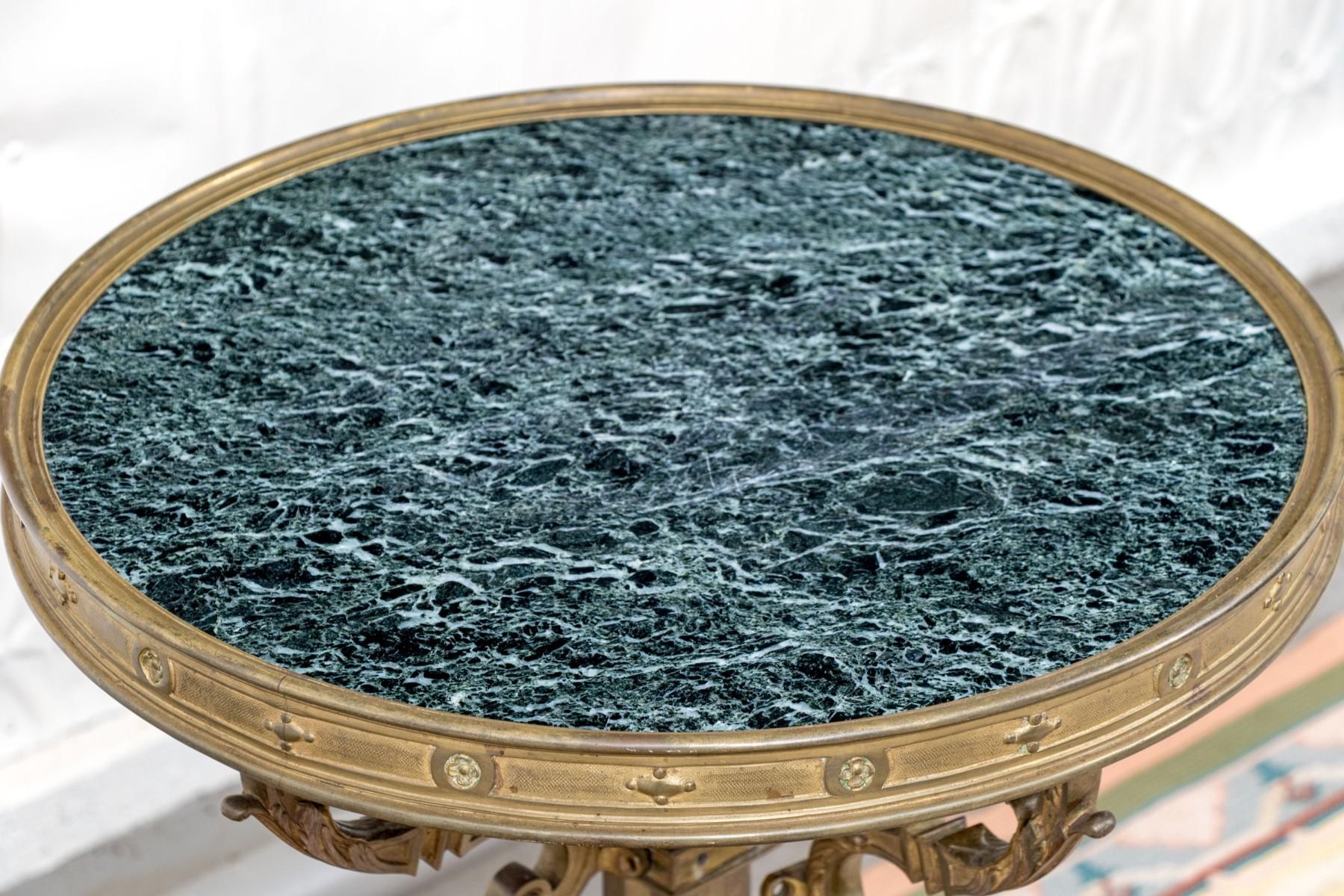 Antique bronze gueridon in the French Napoleon III period style with variegated charcoal/green marble top and x-form stretcher and scrolling foliate supports.  30 1/4 inches tall and top with 18 1/2 inch diameter.