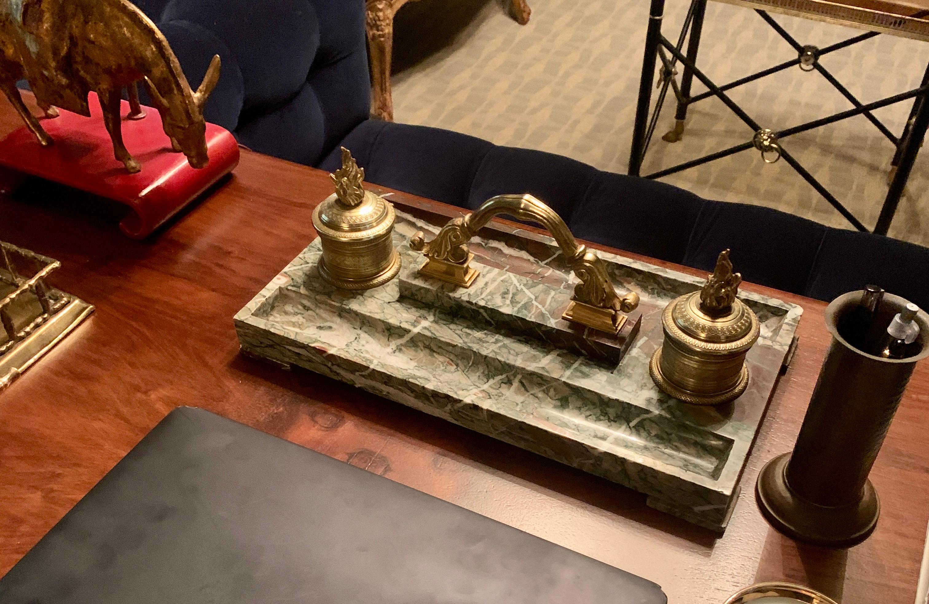 French marble inkwell with bronze details and two ink wells. 

The piece is designed with a decorative handle which makes it very easy to move from desk... The ink wells both contain the original glass inserts and are in good condition. The marble