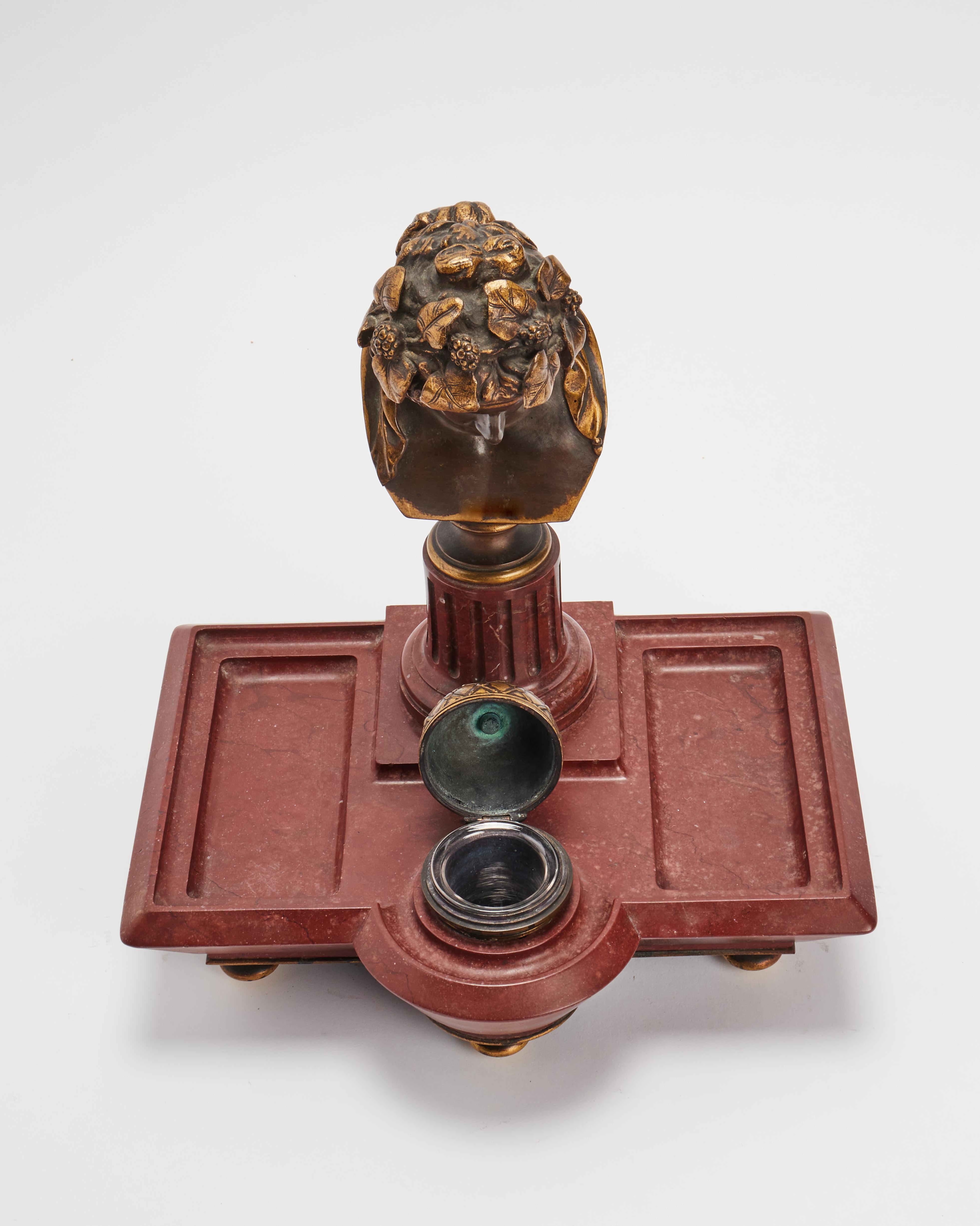 A Verona red marble remarkable inkwell, pure Empire style representing a gilded bronze of the bust of Antinous as Dioniso. Empire style, Generous size, excellent state of preservation.France. Signed by Ferdinand Barbedienne foundry. Paris, France