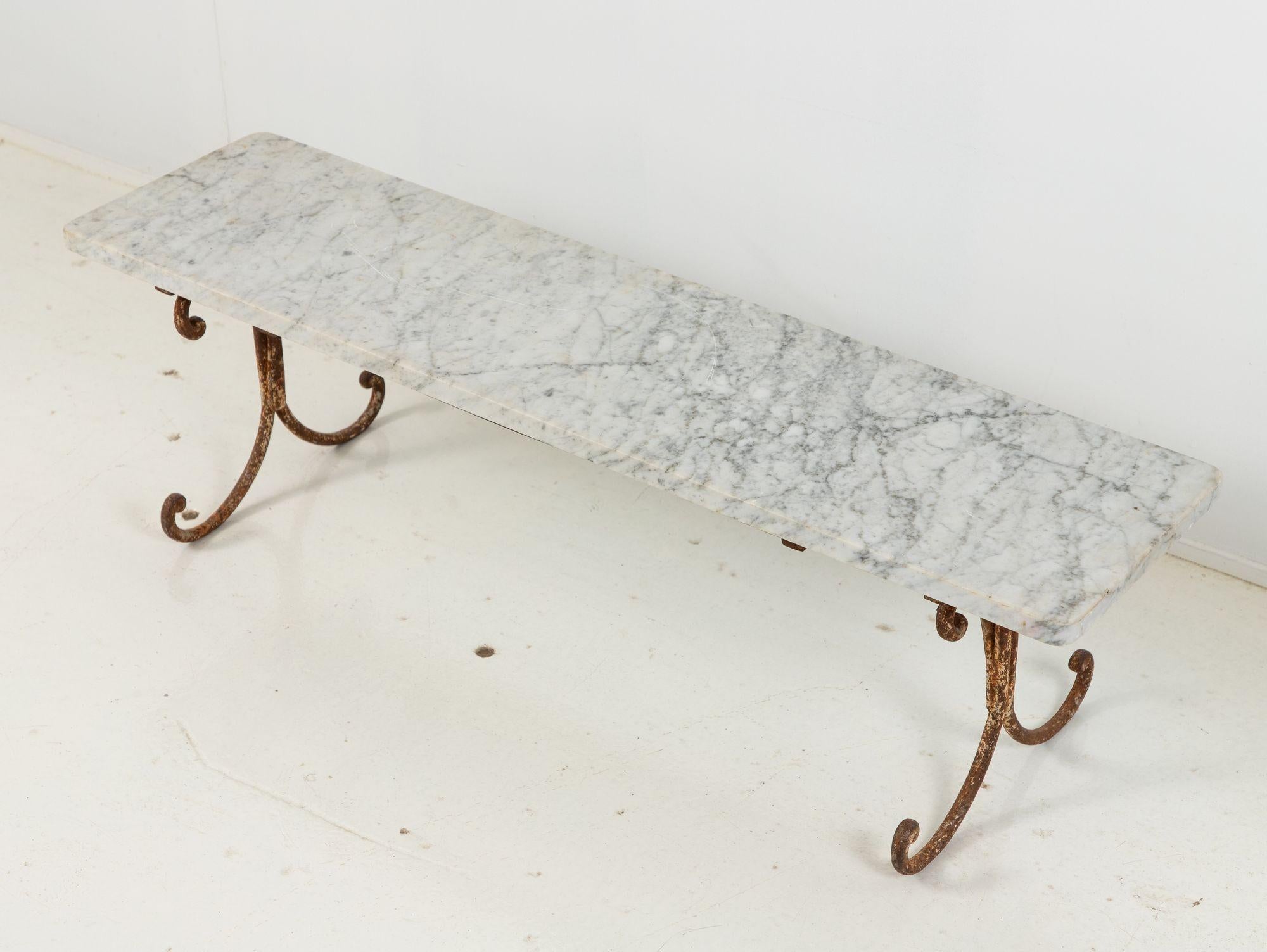 Transport yourself to the enchanting world of 1940s French elegance with this exquisite marble dessert stand. Its opulent allure is matched by the delicately crafted iron scroll legs, forming a harmonious fusion of materials and eras. This