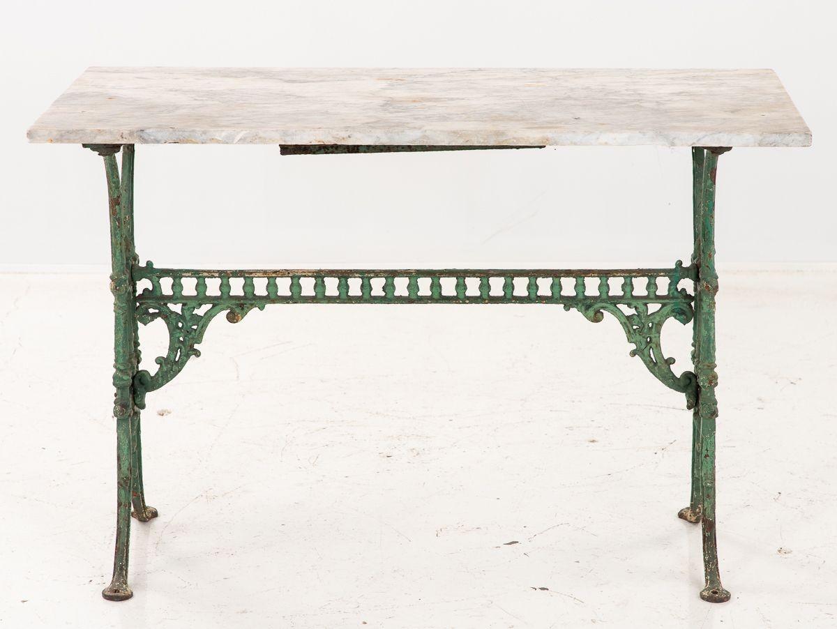 A late 19th century French patisserie table with original marble top. The iron base has four splay legs and a later verdigris paint. These tables were used in cafes and as work tables for patisseries. Wear consistent with age and use.