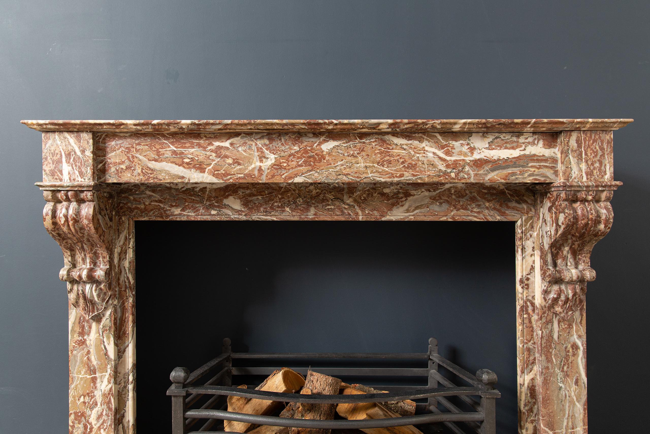 Stately red marble antique fireplace. This front model has a beautiful expressive appearance. The marble contains different colored veins, which gives this fireplace its unique appearance. The difference in depth in the front gives this antique