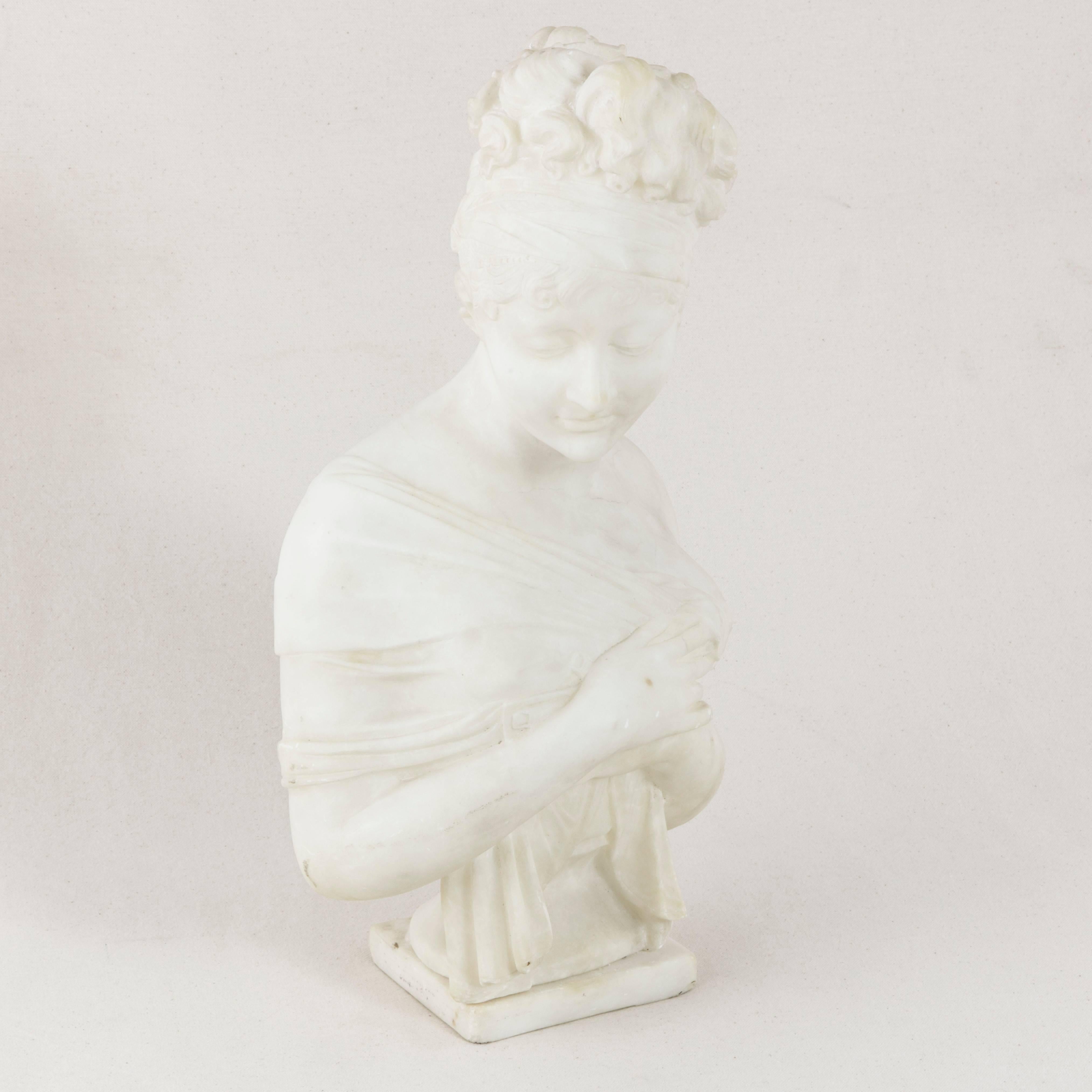 This turn of the 20th century solid marble bust depicts celebrated French beauty, Juliette Recamier, close friend of Josephine de Beauharnais, the first wife of Napoleon Bonaparte. Closely associated with the First Empire in France, Madame Recamier