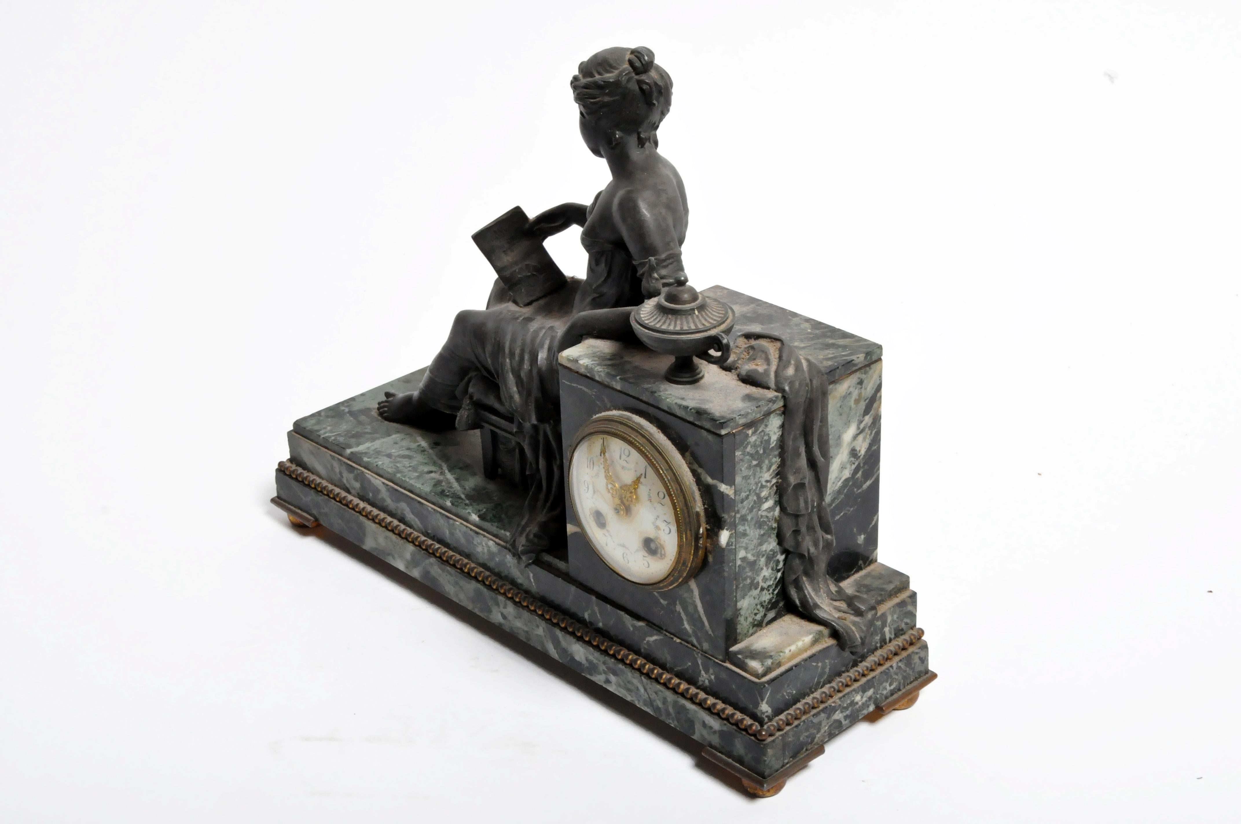 This elegant mantel clock features a reclining woman reading by lantern light. The clock was made in France from cast bronze and marble and dates to the 19th century. Movement is original there is no key. Operation uncertain.