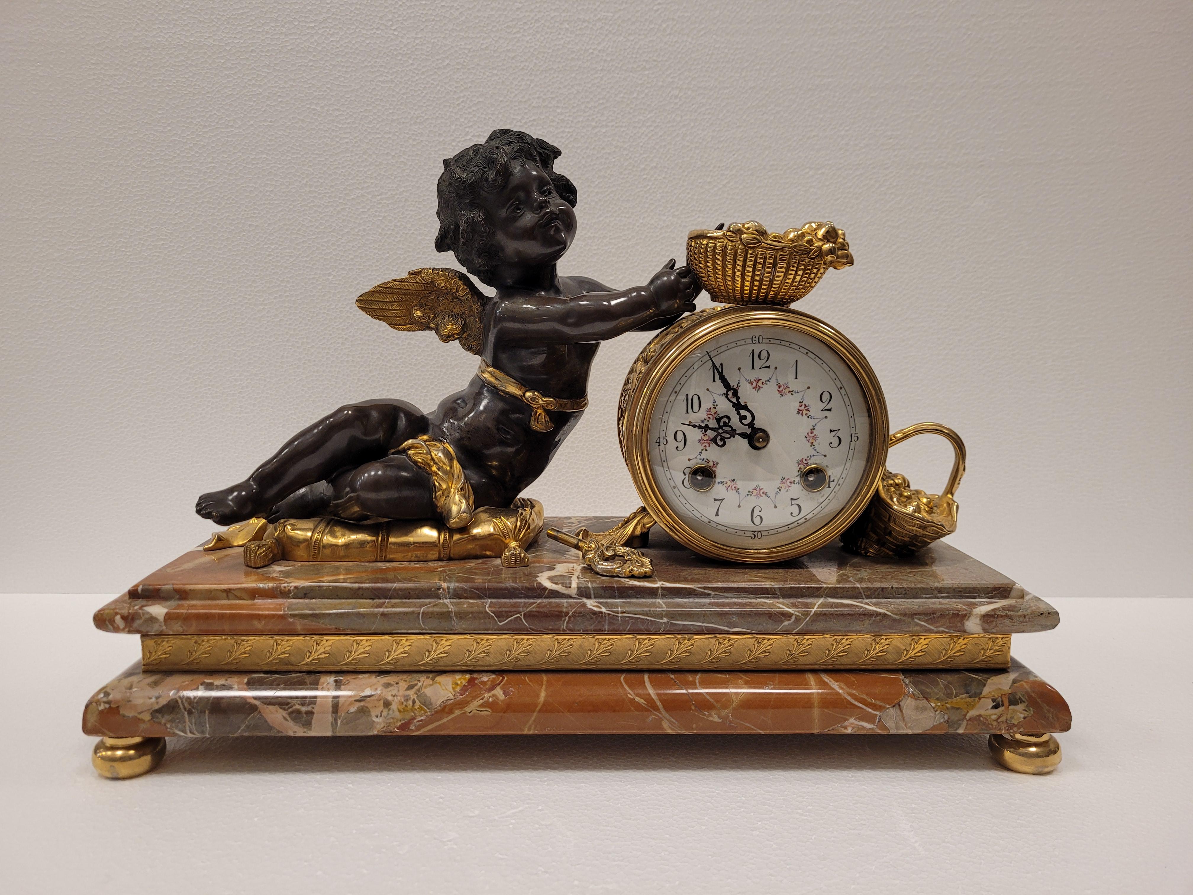 One of a kind Mantel clock in gild bronze, ormolu ,and breche marble base. It represents an angel or putti with baskets of fruit and a barrel that is the clock. Supports on a mink colored breche marble base, embellished with a chiselled golden