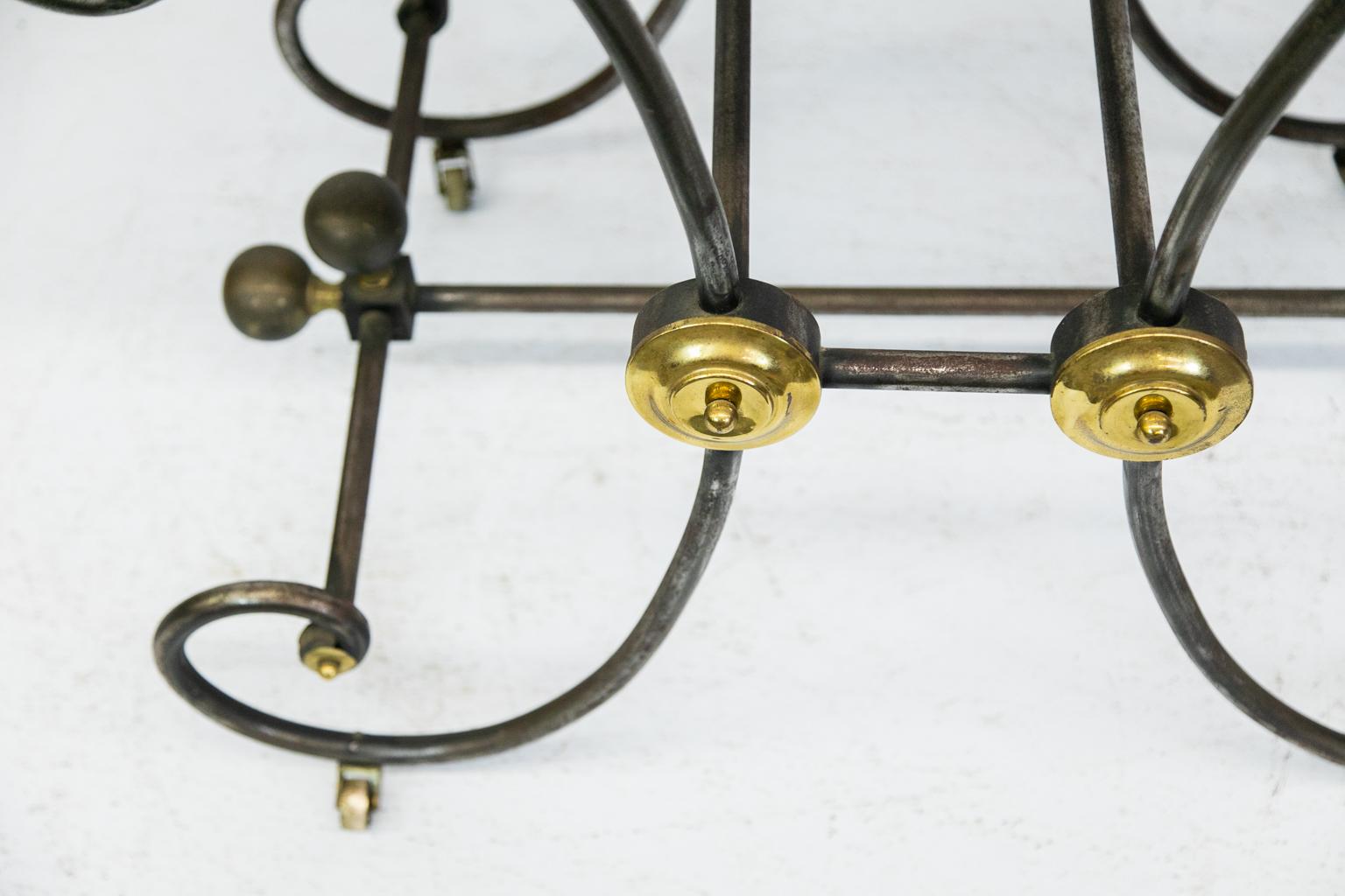 French marble-top Baker’s table, the base is steel with brass highlights on all four sides, and it rests on its four original castors.
 