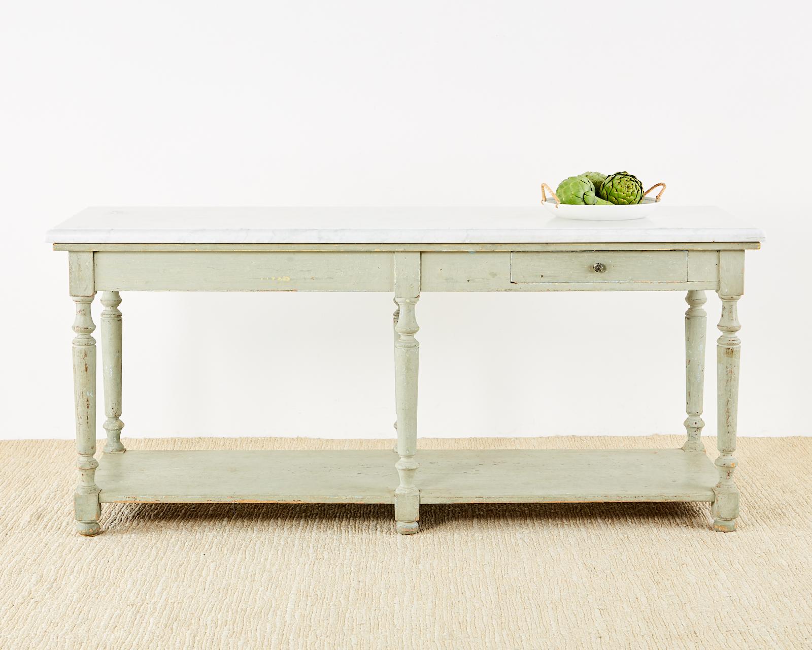 Rustic 19th century French baker's table or kitchen island featuring a large rectangular 1.5 inch thick slab of Italian Carrara marble. The large base measures 78 inches long by 27 inches wide with a distressed lacquer patina in a Gustavian style