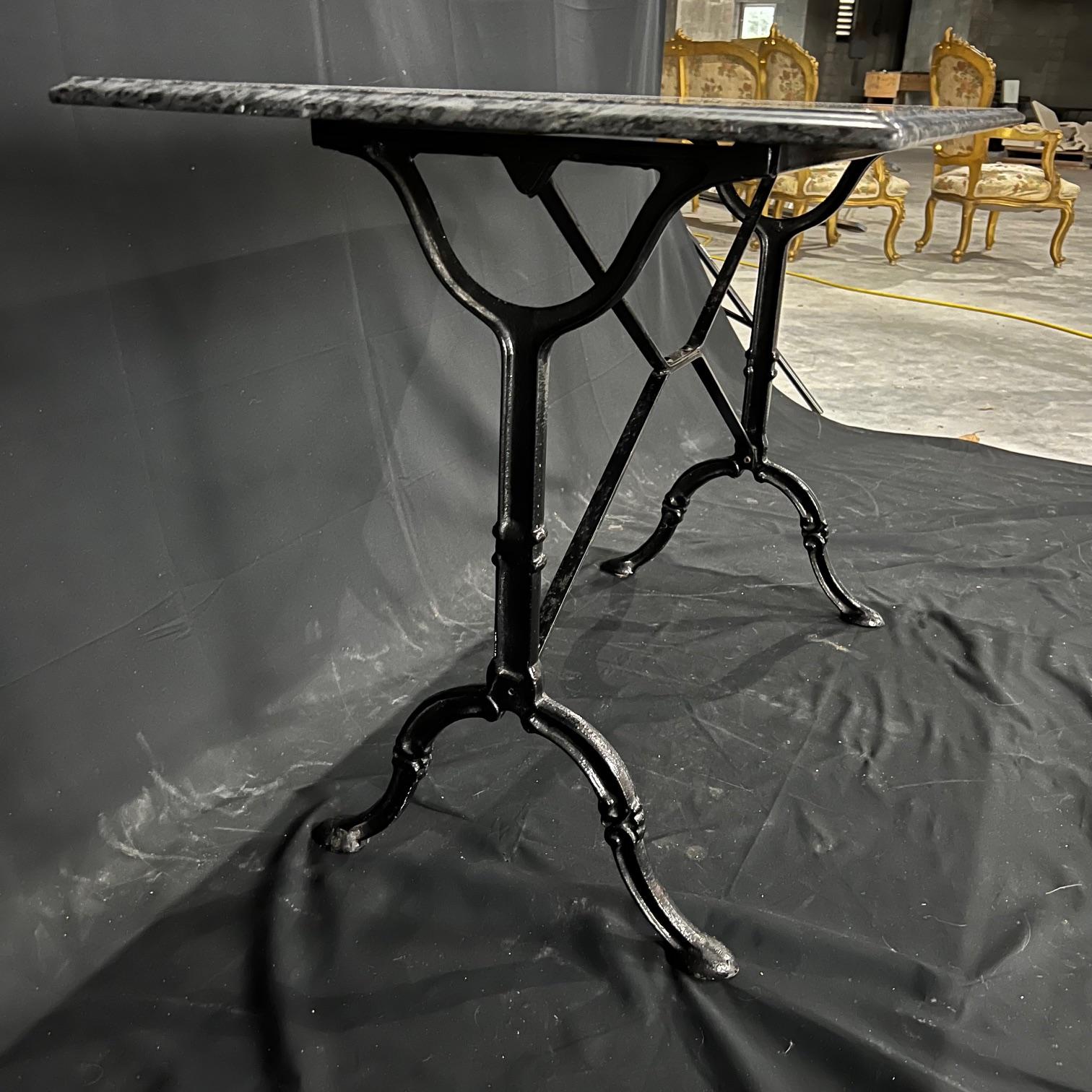 Versatile French marble top rectangular cafe table or writing desk with a classic Provencal black iron base. Marble is a stunning black marble with veining. There are some scratches at one end commensurate with age. Very nice beveled edge on all