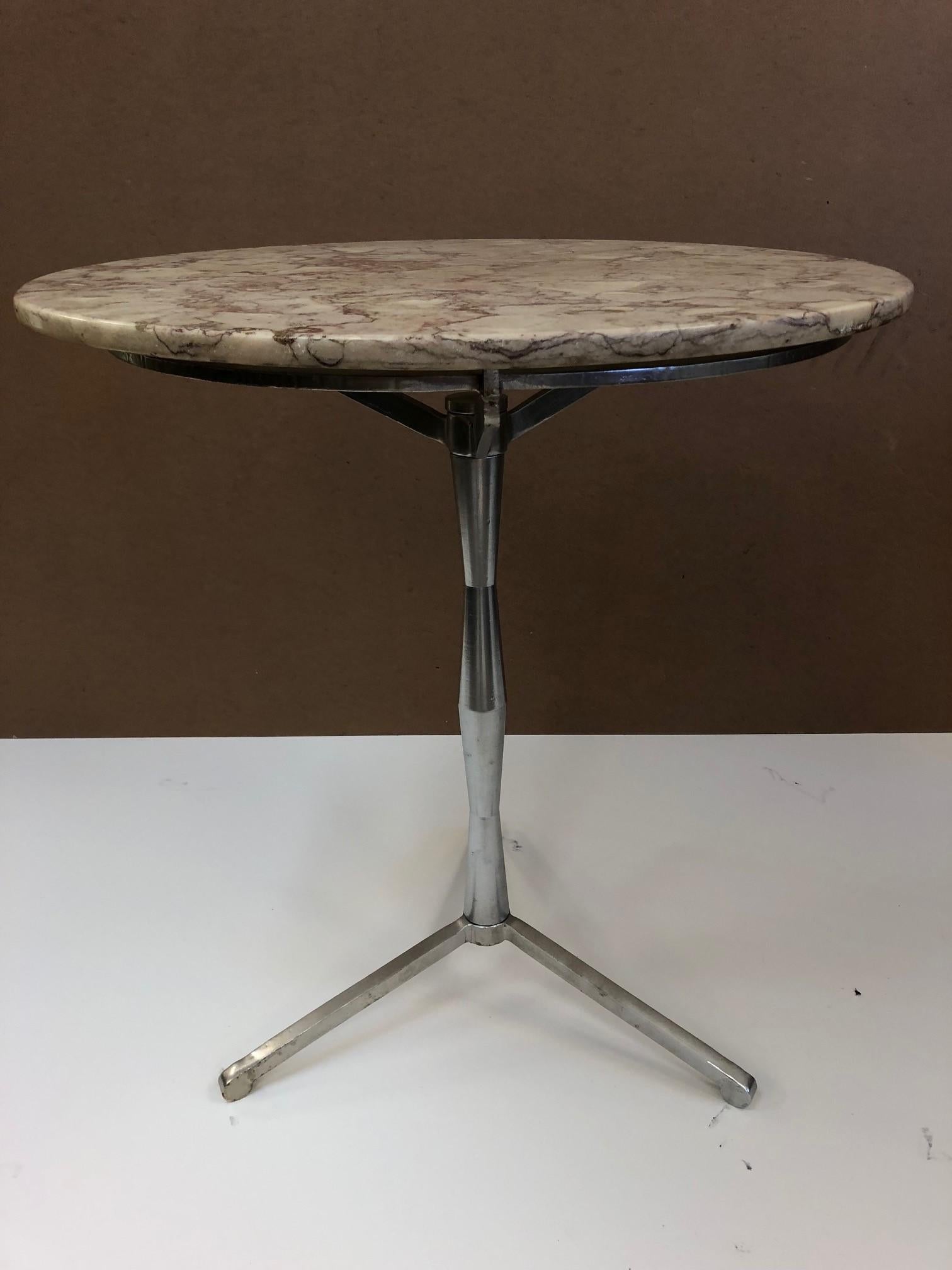 Round marble-top Bistro table with a three-leg, steel pedestal base.