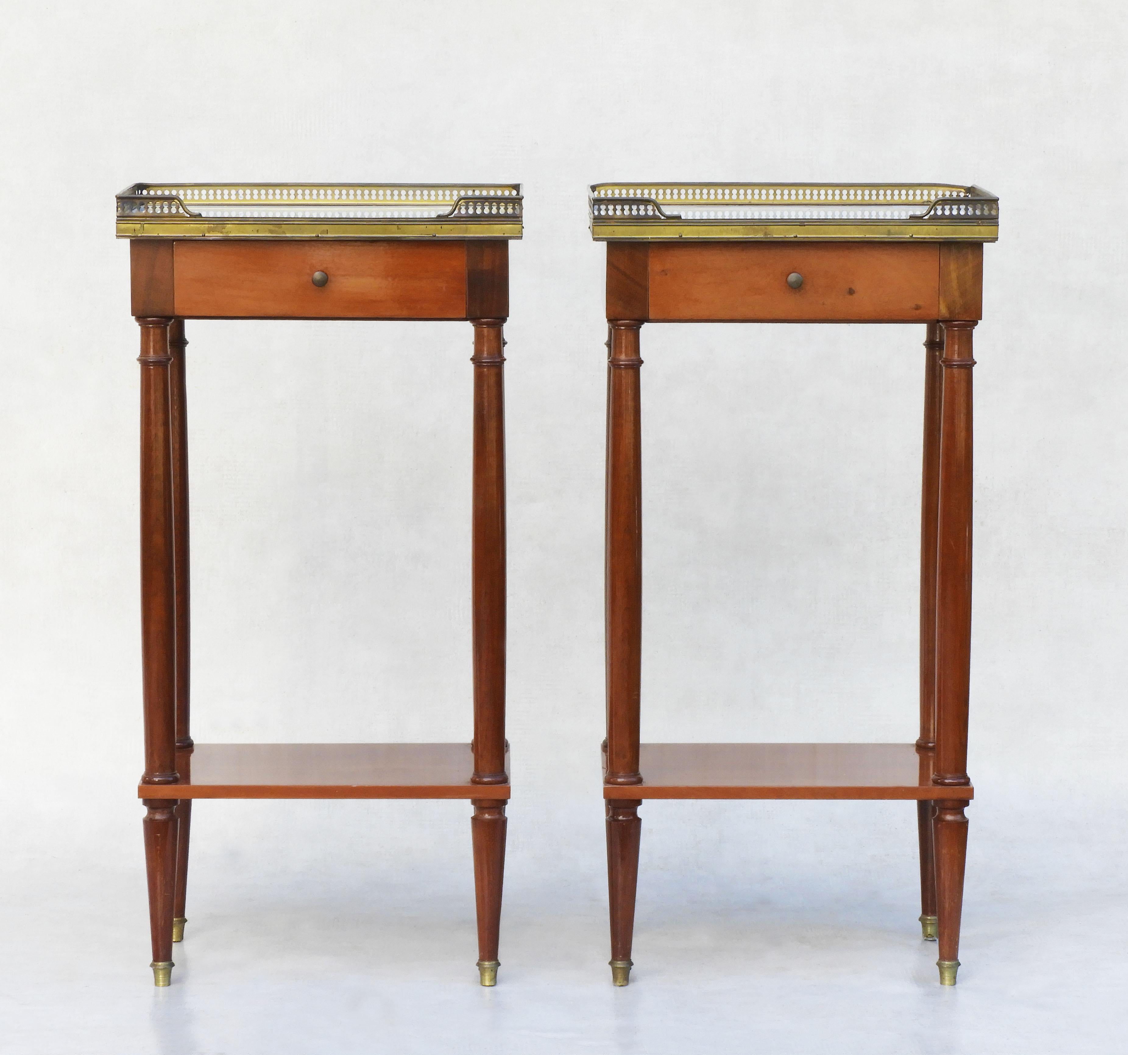 Elegant pair of French nightstands or side tables C1960.
Classicly styled, single-drawer cabinets with marbled tops, tapered legs, pierced brass gallery, brass drawer findings and cloched feet. Finished on all four sides, these tables work equally