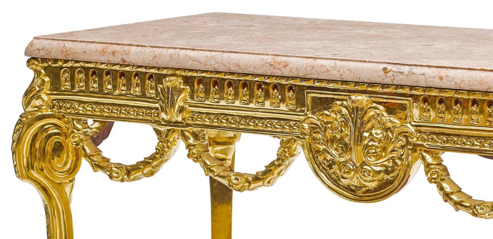 Exquisite French Louis XVI style carved gold leafed console table with marble top.
20th century. 

Thick rectangular moulded marble top over a foliate-inspired 23-karat gold leafed carved giltwood frieze, trimmed with a guilloche and decorated