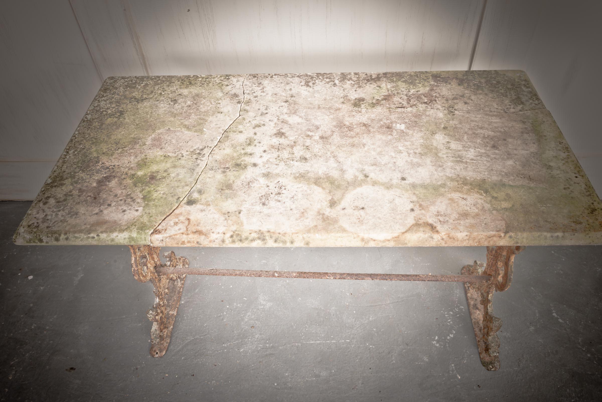 Typical of the Art Nouveau period, with its aged marble top and supported by its elaborately designed cast iron leg base, this table would be suitable for both in the garden or as a decorative piece within the home. Originally designed in the south