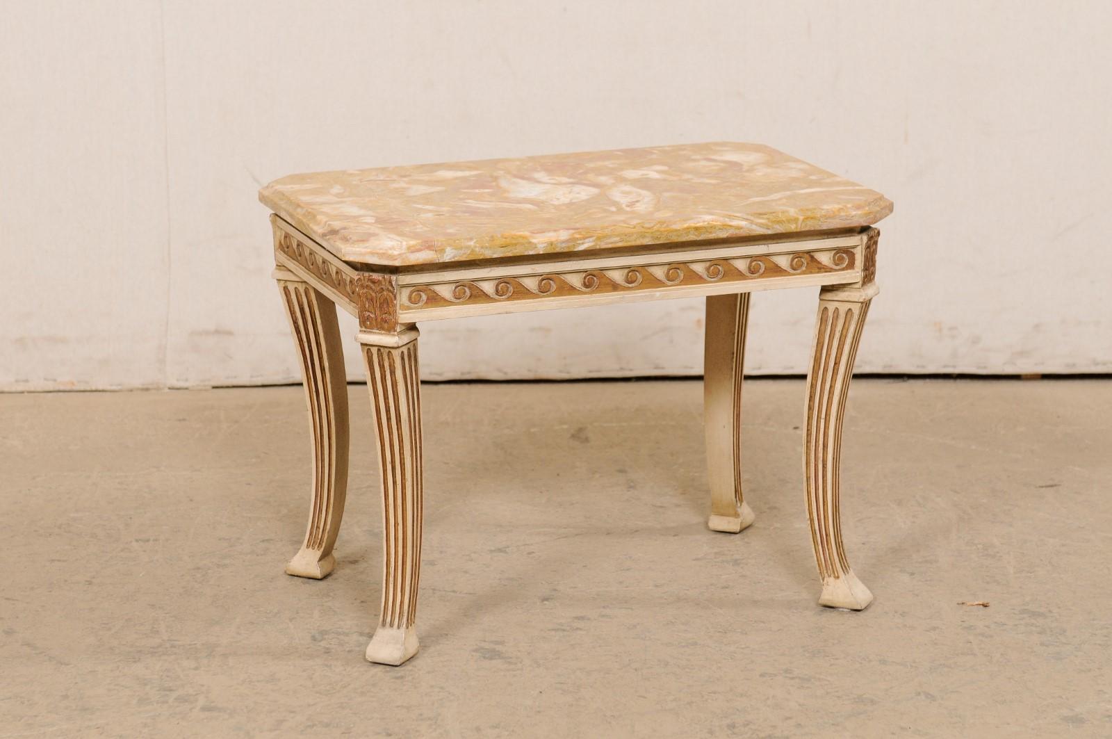 A French nicely carved drinks table with original marble top. This cute little vintage side (or small coffee table) from France features a rectangular-shaped marble top with chamfered edging and canted corners, which rests atop a skirt adorn with