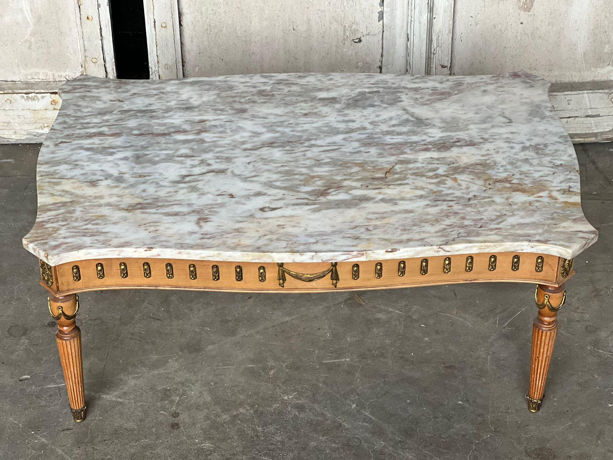 A pretty French coffee table having a lovely variegated marble top if perfect condition. Nice serpentine shape to all sides and brass embellishments to the base. 
In excellent original condition for the home.
Measures: length 95.5 cm
depth 55.5