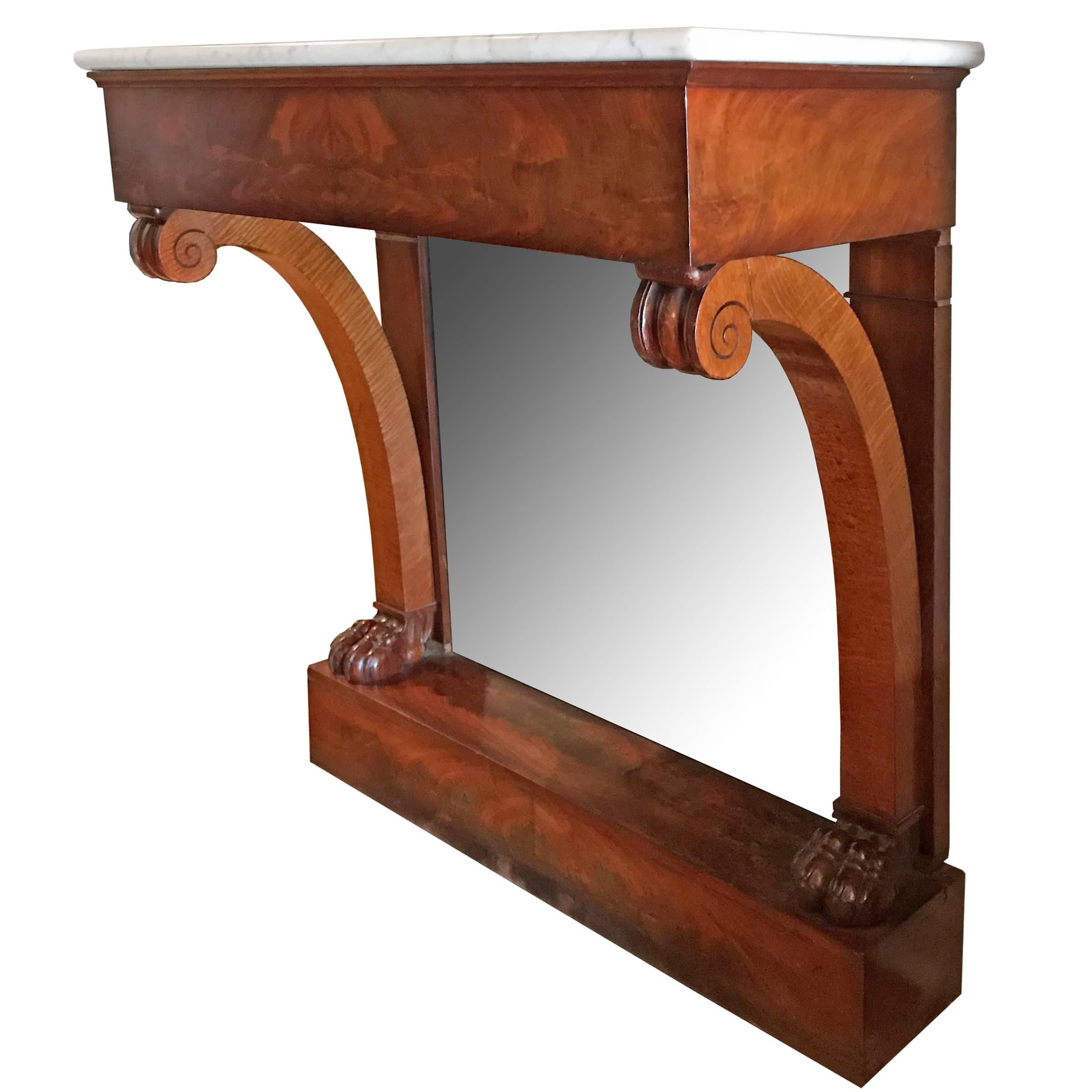 A late 19th century French bookmatched flame mahogany pier console table with white marble top, lion paw feet, and a mirror. Table mounts to the wall.