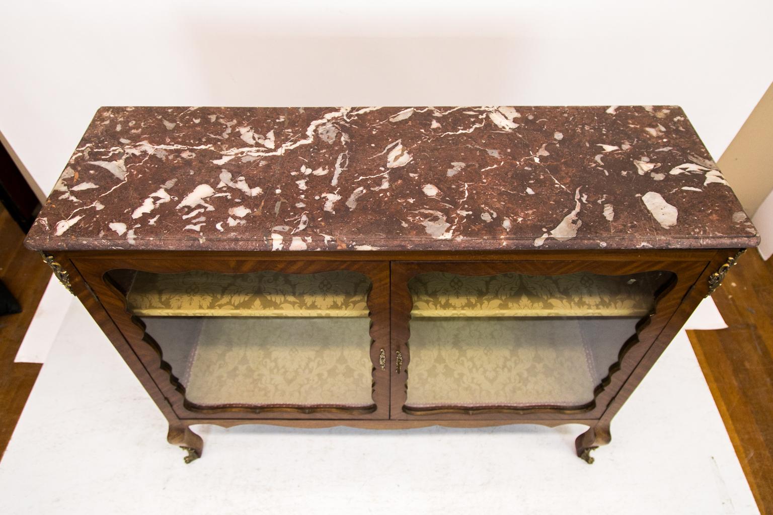 - This French marble-top display/bookcase has doors with a scalloped shape and are crossbanded with bookmatched flame mahogany. The sides have flamed bookmatched mahogany panels. The interior and shelf are covered with a floral green damask