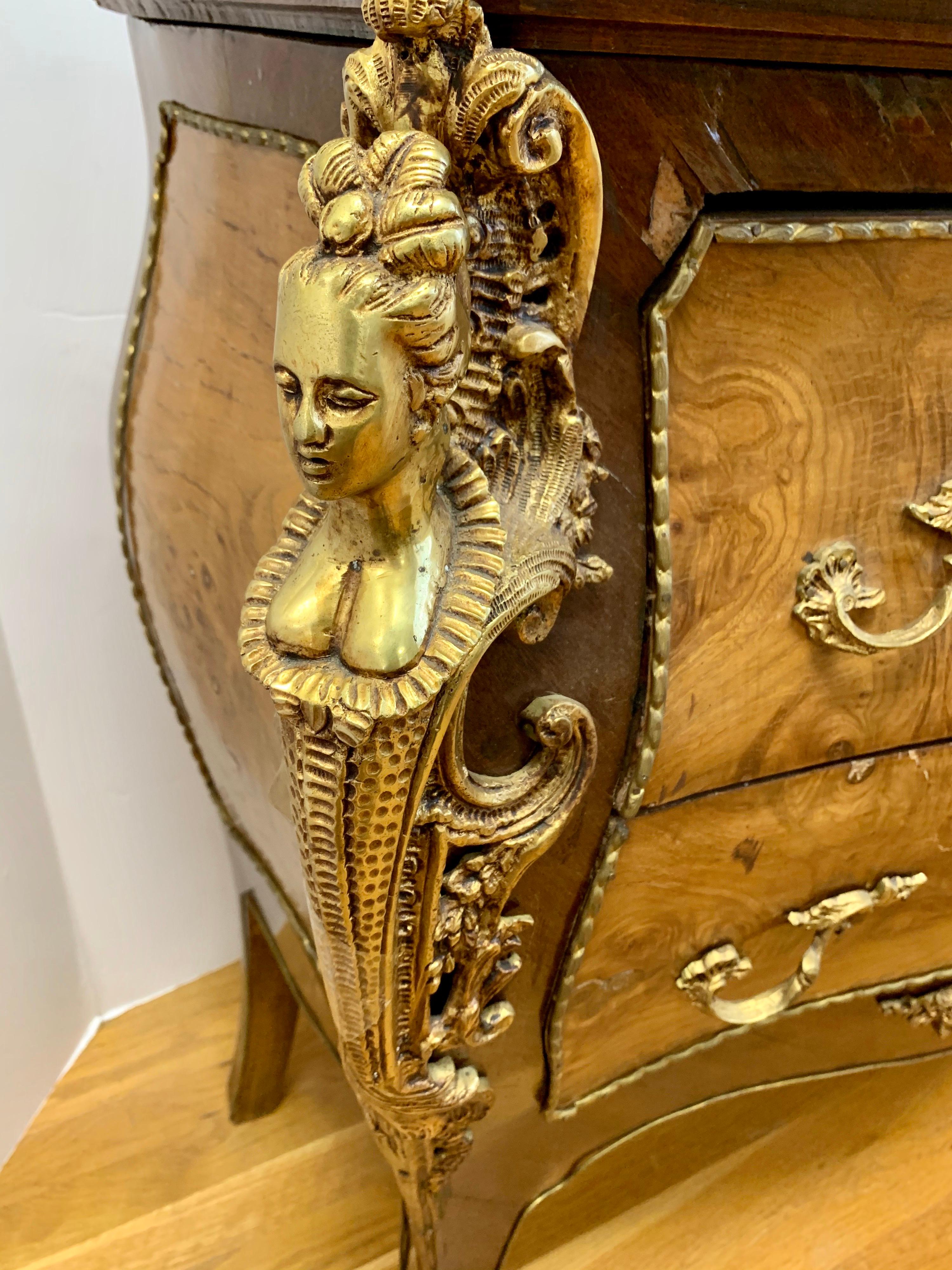 Elegant French marble top inlaid bombe chest of drawers with mounted bronze ormolu throughout,
circa mid-20th century. Now, more than ever, home is where the heart is.