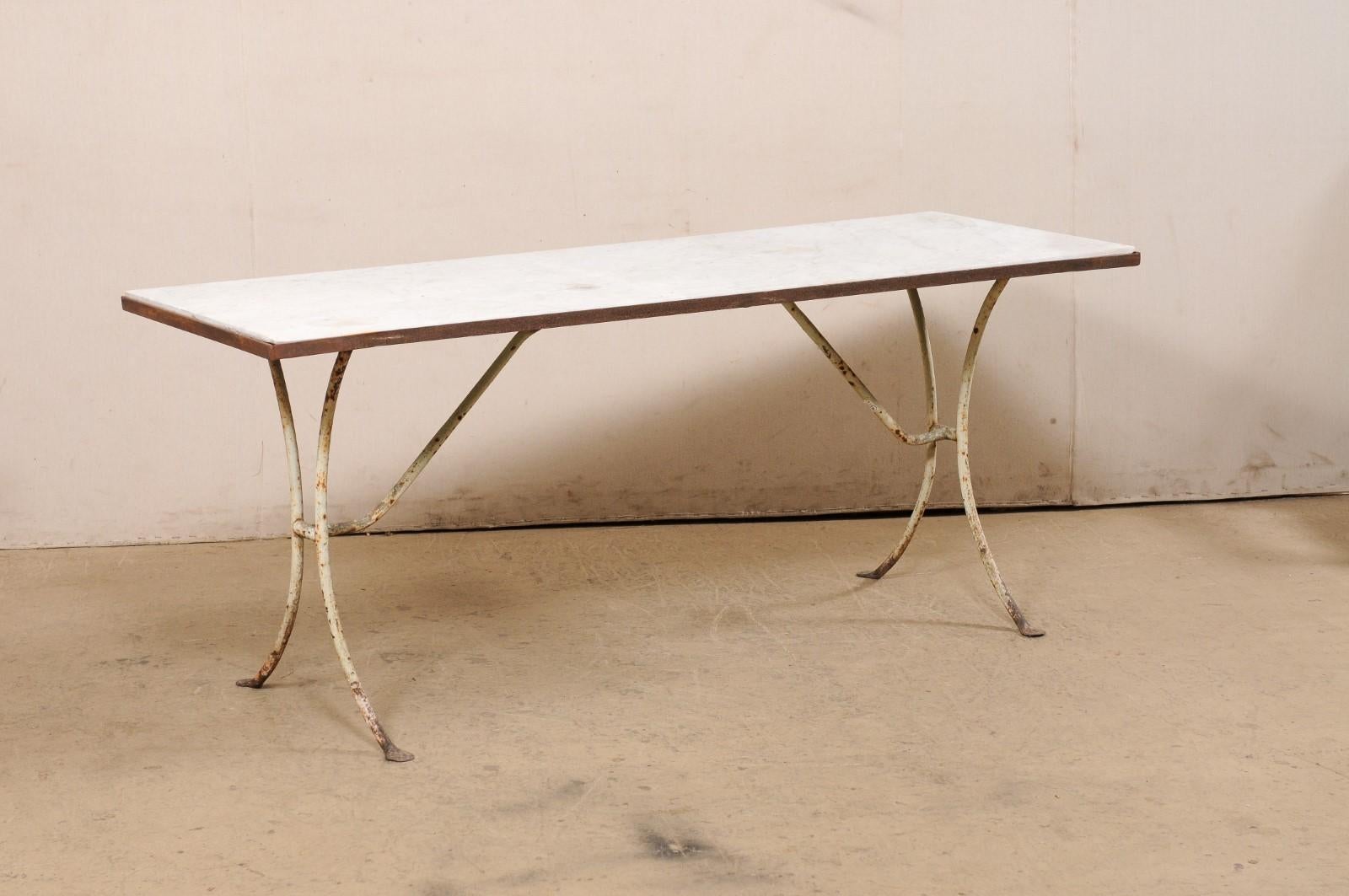 A French marble top table on iron base from the 19th century. This antique table from France features a rectangular-shaped marble top which is recessed into an iron frame and raised upon iron legs which is comprised of a pair of inverted
