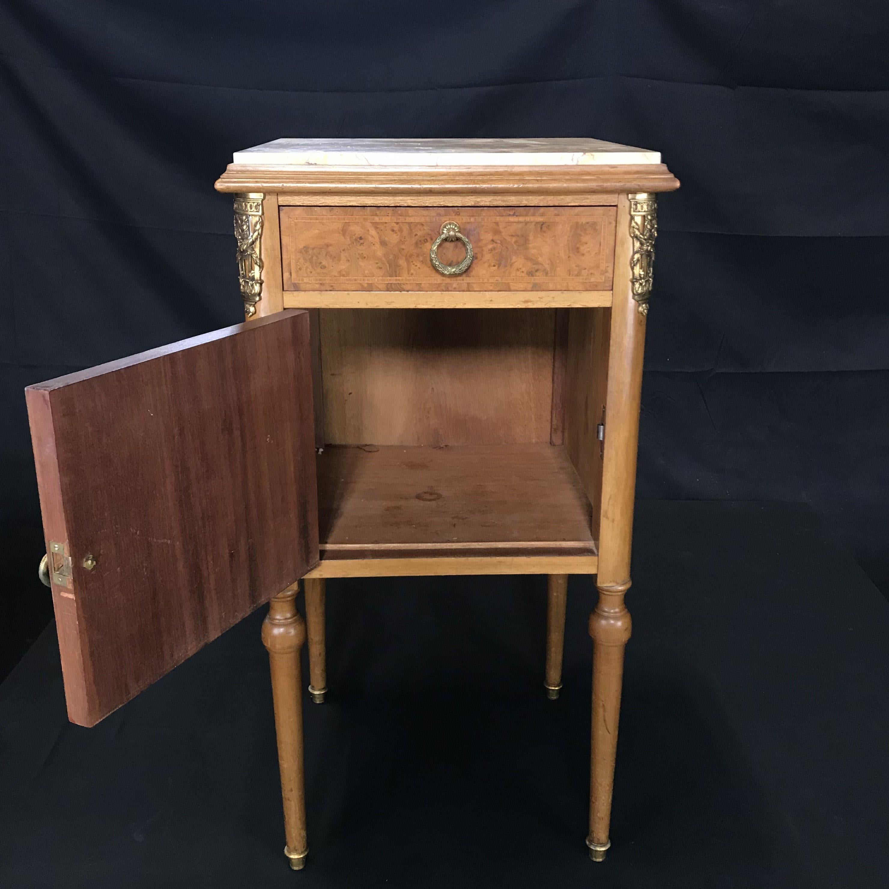Much versatility in this beautiful inlaid French marble top night stand, bedside table or side table. Lovely inlay on the front under a beige/ivory marble top, with one dovetailed drawer and an open cabinet below. Perfect in a bedroom, bathroom or