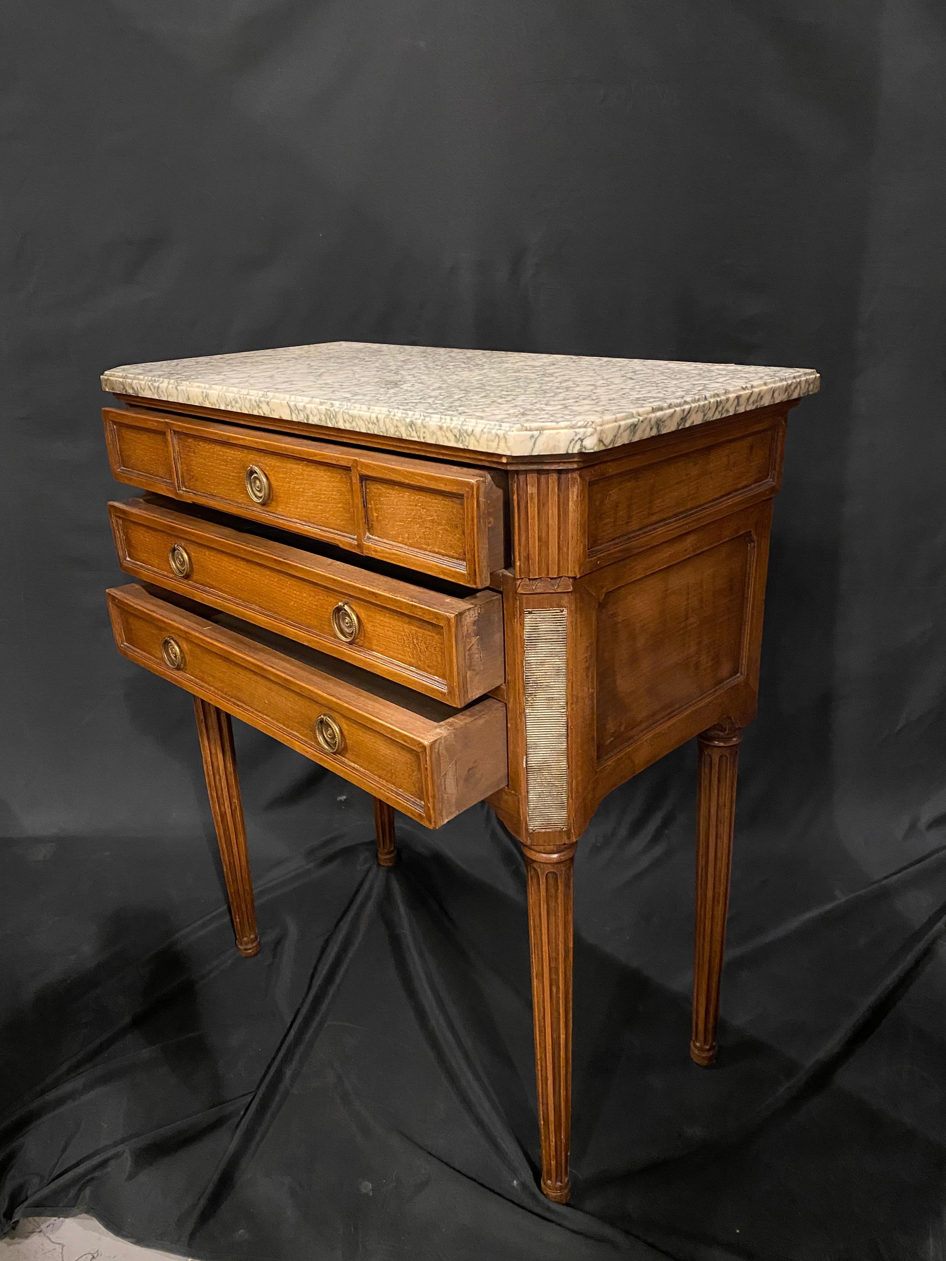 A nice proportioned French end or side table with a light walnut stain and off white and black grain marble top.
Traditional Design with the subtle ormolu mounts Three drawers make it useful in many rooms of the house.