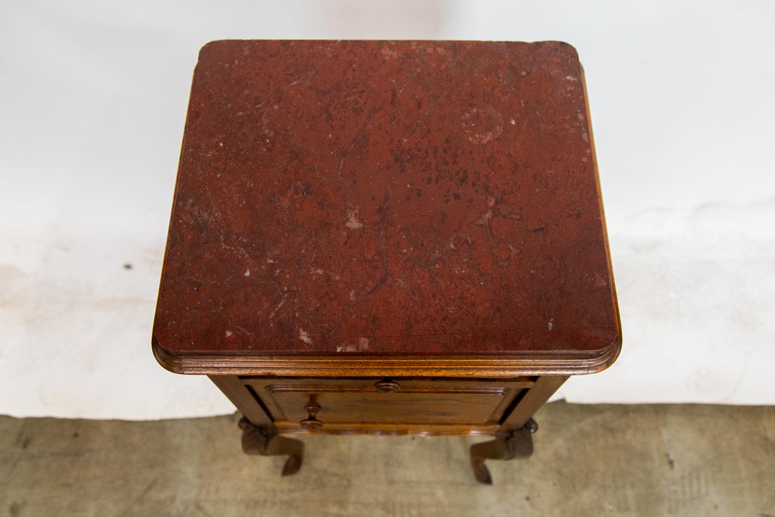 The top of this night stand has shaped molding. The drawer and cupboard door both have shaped raised panels and the original turned knobs. The lower apron has shaped carved molding which extends down the legs to the feet on all four legs. The knees