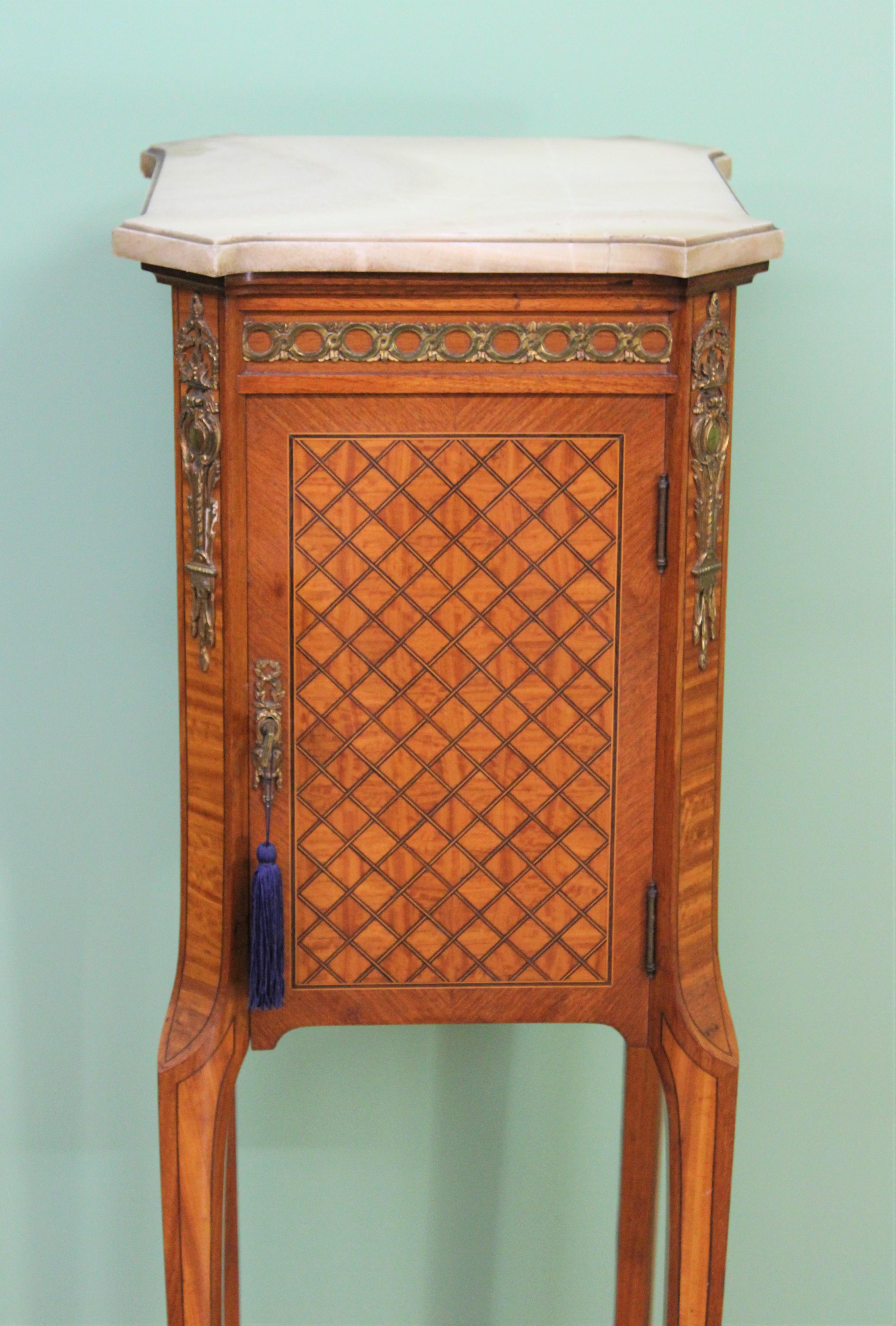 A splendid quality French marble topped cabinet in the Louis XVI style. Of fine construction in satinwood and kingwood and decorated with stunning inlaid parquetry work. Further embellished with crisply cast brass mounts. There is a shaped marble