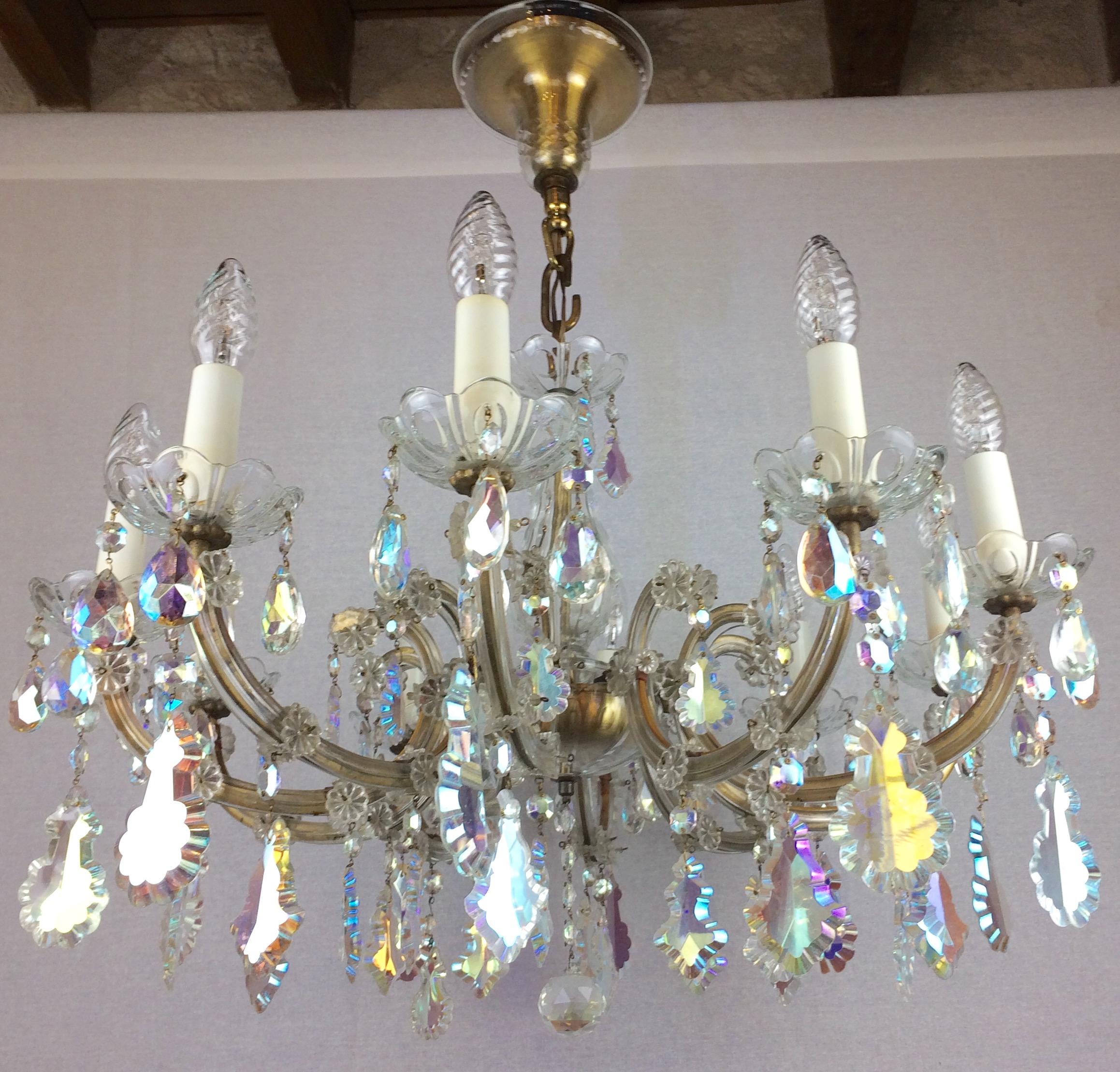 A stunning 10 arm chandelier fully arranged with colored rock crystals and drops. This antique chandelier is in very good condition, recently rewired. Fully decorated with various hand cut crystals that capture and reflect the light, resting in