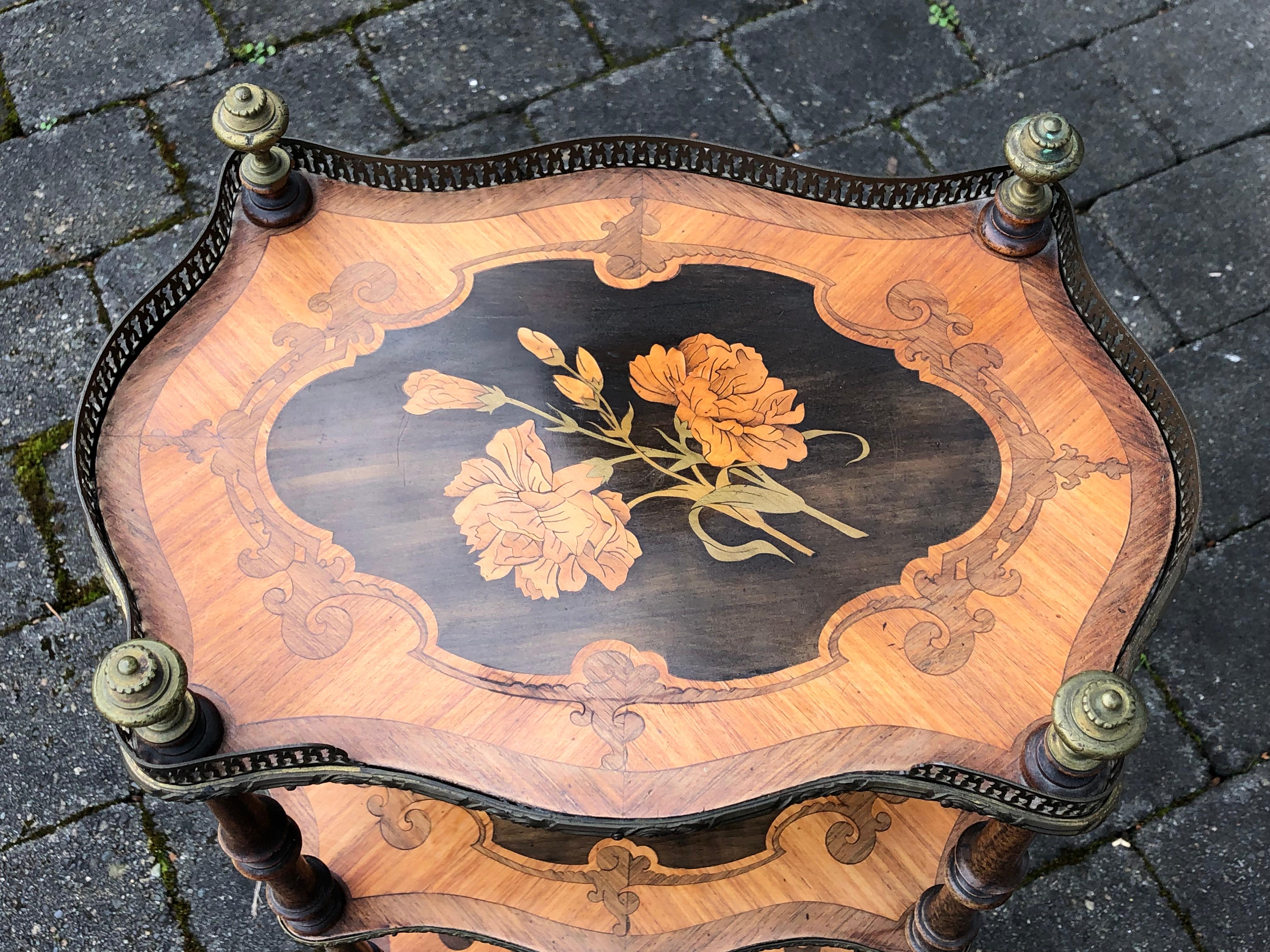 Beautiful small French side table with large scale floral motif, carnations on top two levels. 

Bronze finials on the top and galleries on each level. 

Carved scroll feet.