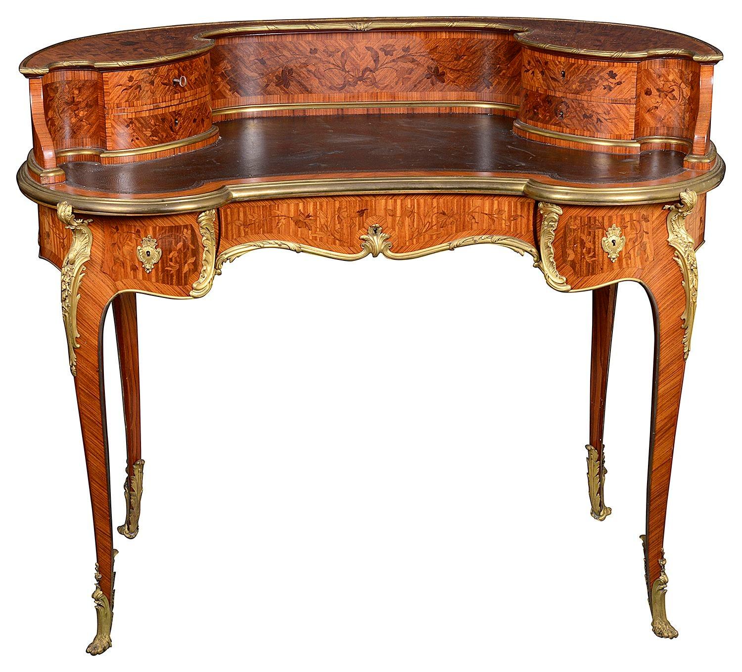 A fine quality late 19th Century French free standing Ladies bureau de dame. Having wonderful floral marquetry inlaid decoration, drawers above, an inset leather top, drawers beneath, raised on elegant cabriole legs with gilded scrolling ormolu