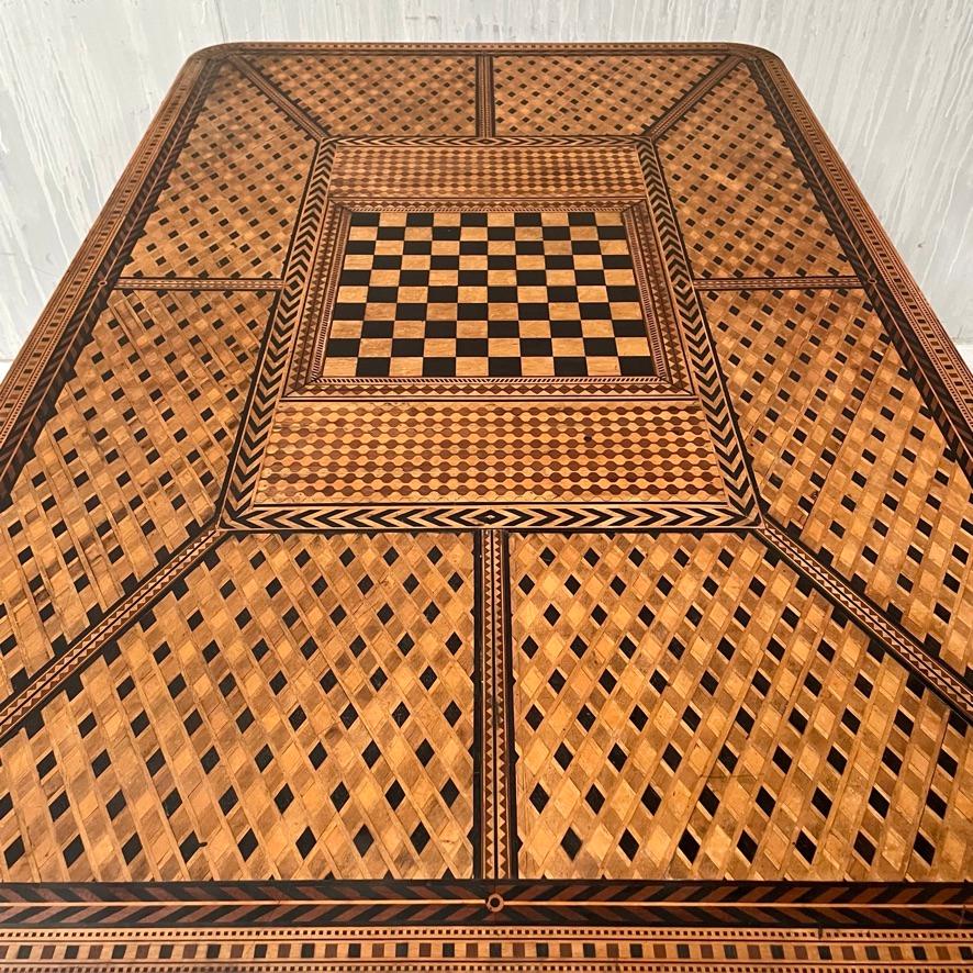 Entdecken Sie ein wahres Meisterwerk der Handwerkskunst mit diesem exquisiten Spieltisch aus französischem Holz mit Intarsien. Dieses atemberaubende Stück ist ein seltener Fund, höchstwahrscheinlich ein Auftragskunstwerk, das sich durch