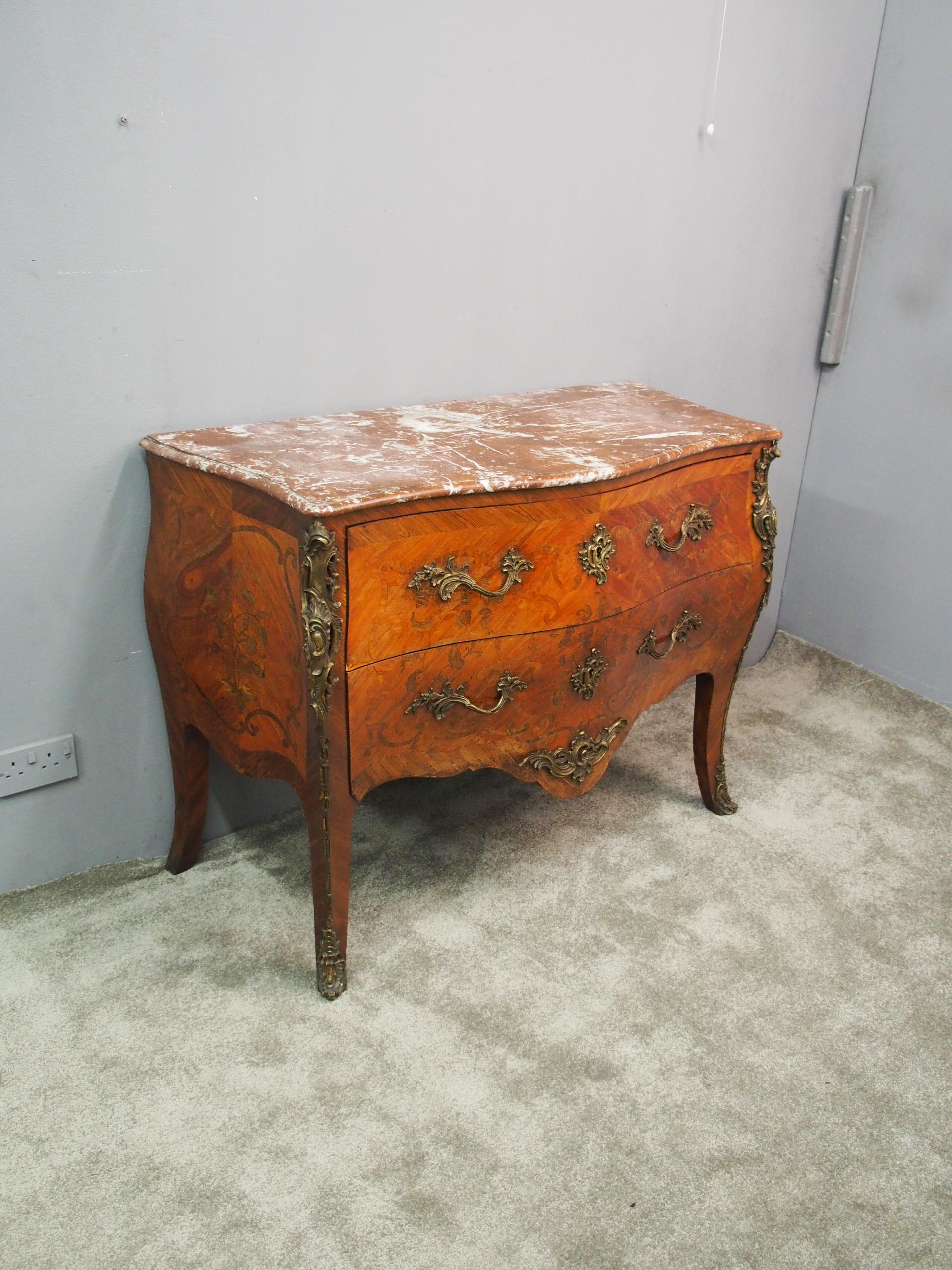 Large French marquetry inlaid Kingwood commode, circa 1860. The serpentine top is in pink variegated marble with a moulded edge over two deep bombe-front, oak lined drawers with marquetry and arabesque inlay, ormolu Rococo handles and escutcheons.