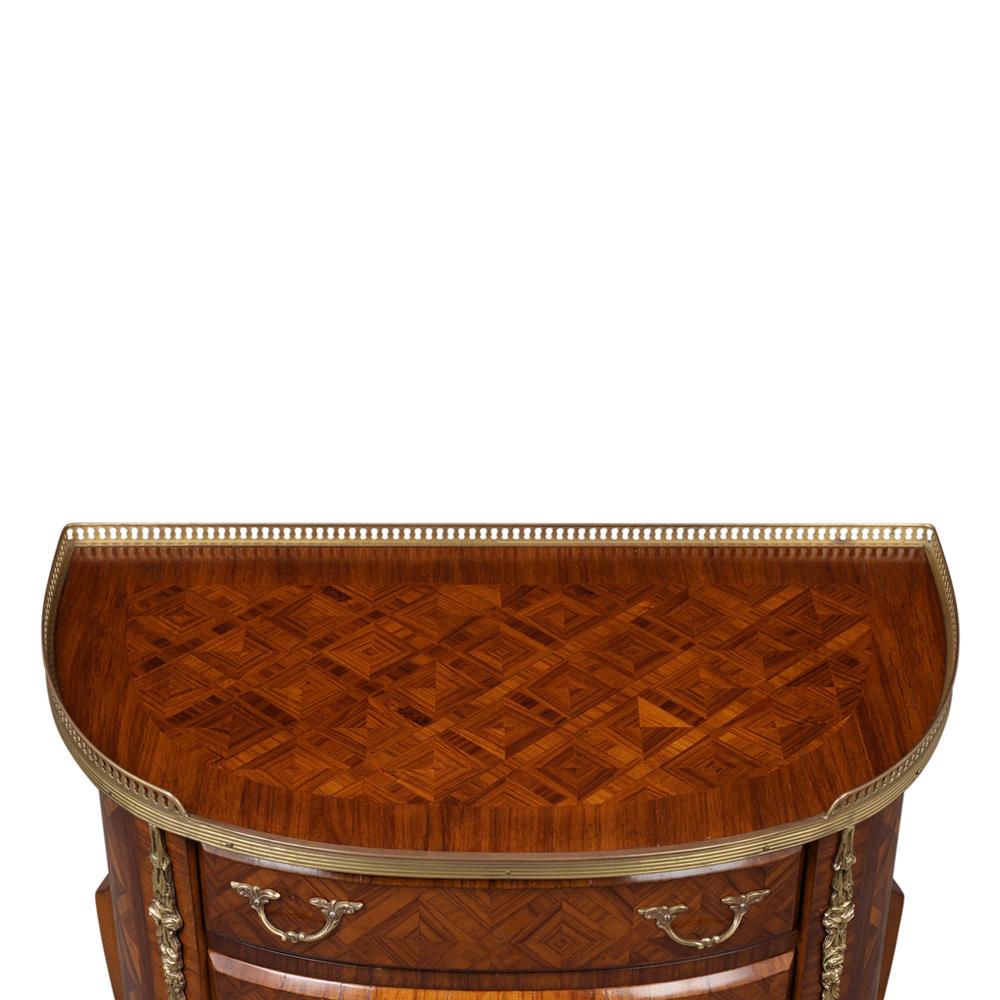 This vintage French Louis XVI style side table is made from mahogany wood beautiful marquetry details mahogany color with a lacquered finish. It features an elegant geometric inlaid design along the top, drawers, and sides of the table. The table