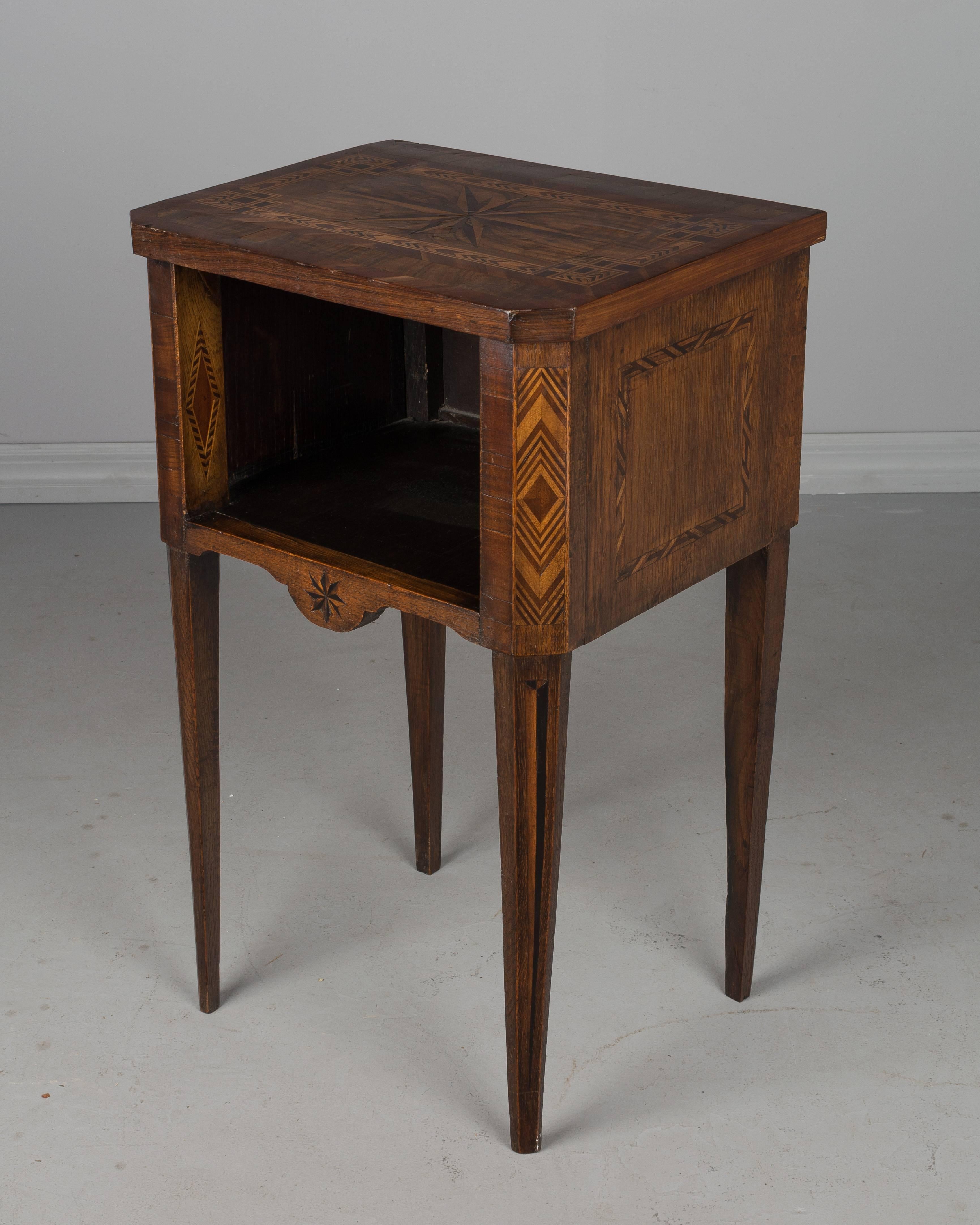 A French Louis XVI style side table made of walnut with fine marquetry inlay and slender legs. In good condition with only minor losses. Please refer to photos for more details. We have a large selection of French antiques at Olivier Fleury, Inc. 