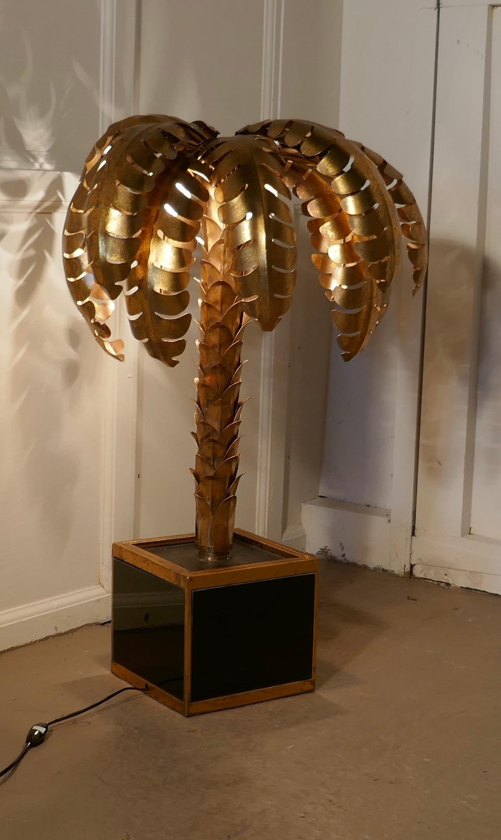 French Mason Jansen Style Palm Tree Tole Ware Table Lamp 

This is a stunning design is Circa 1970

This toleware lamp has a gold finish they have abundant serrated curling brass Palm Leaves overhang a spikey tree trunk, this is set in a gold and