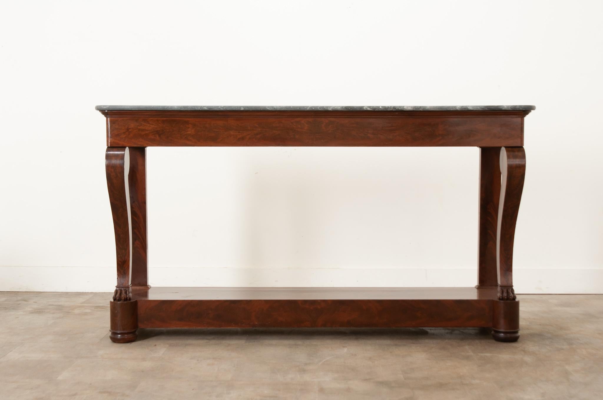 An extraordinary mahogany and marble topped Restauration console – constructed in massive scale – from early 20th century, France. The beautiful piece of antique gray marble has white veins running throughout and rounded front corners which are