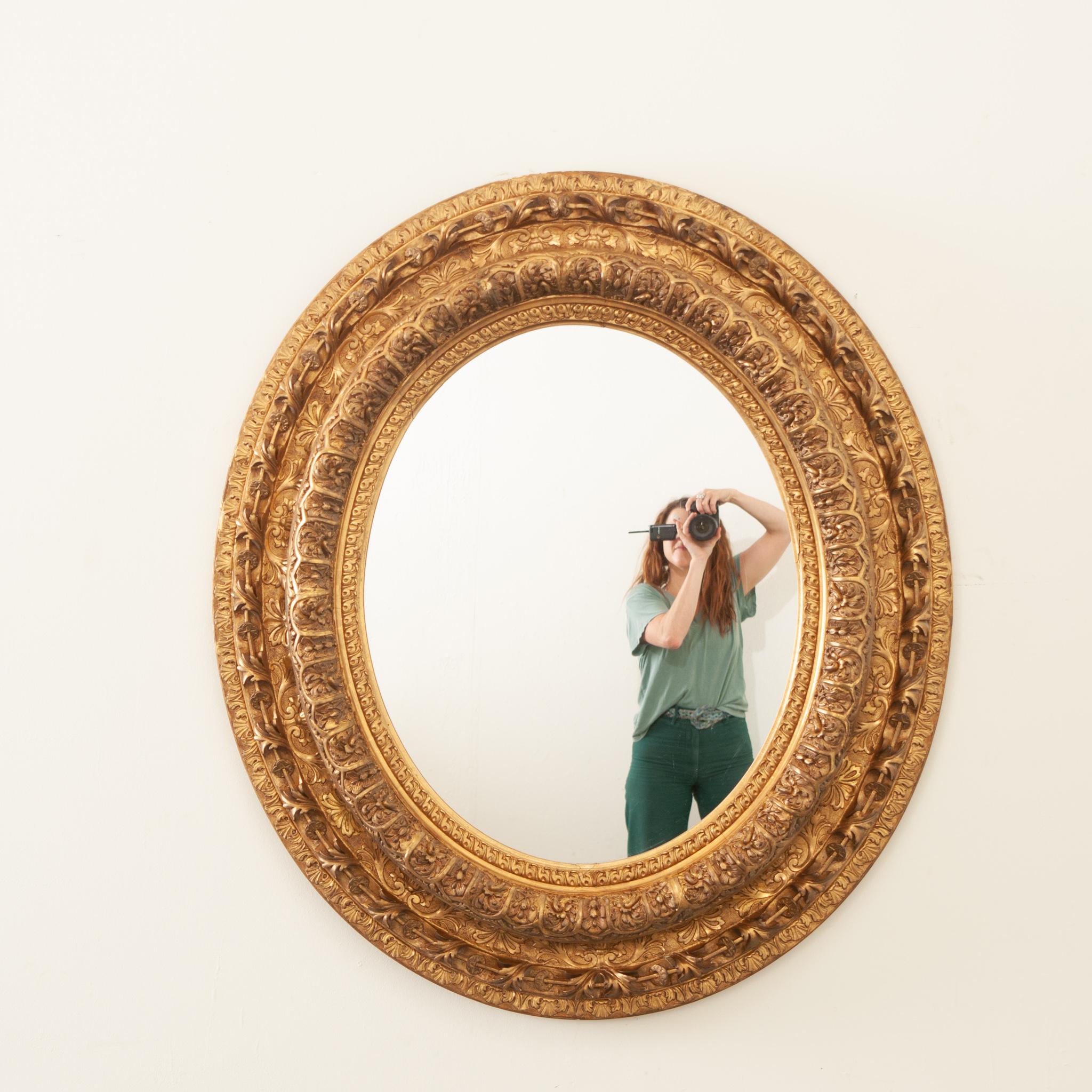 Somptueux miroir ovale en bois doré de style Napoléon III du 19ème siècle. Cet étonnant miroir, fabriqué à la main en France sous le règne de Napoléon III, présente un cadre ovale très décoratif qui est vraiment éblouissant. Richement orné de motifs