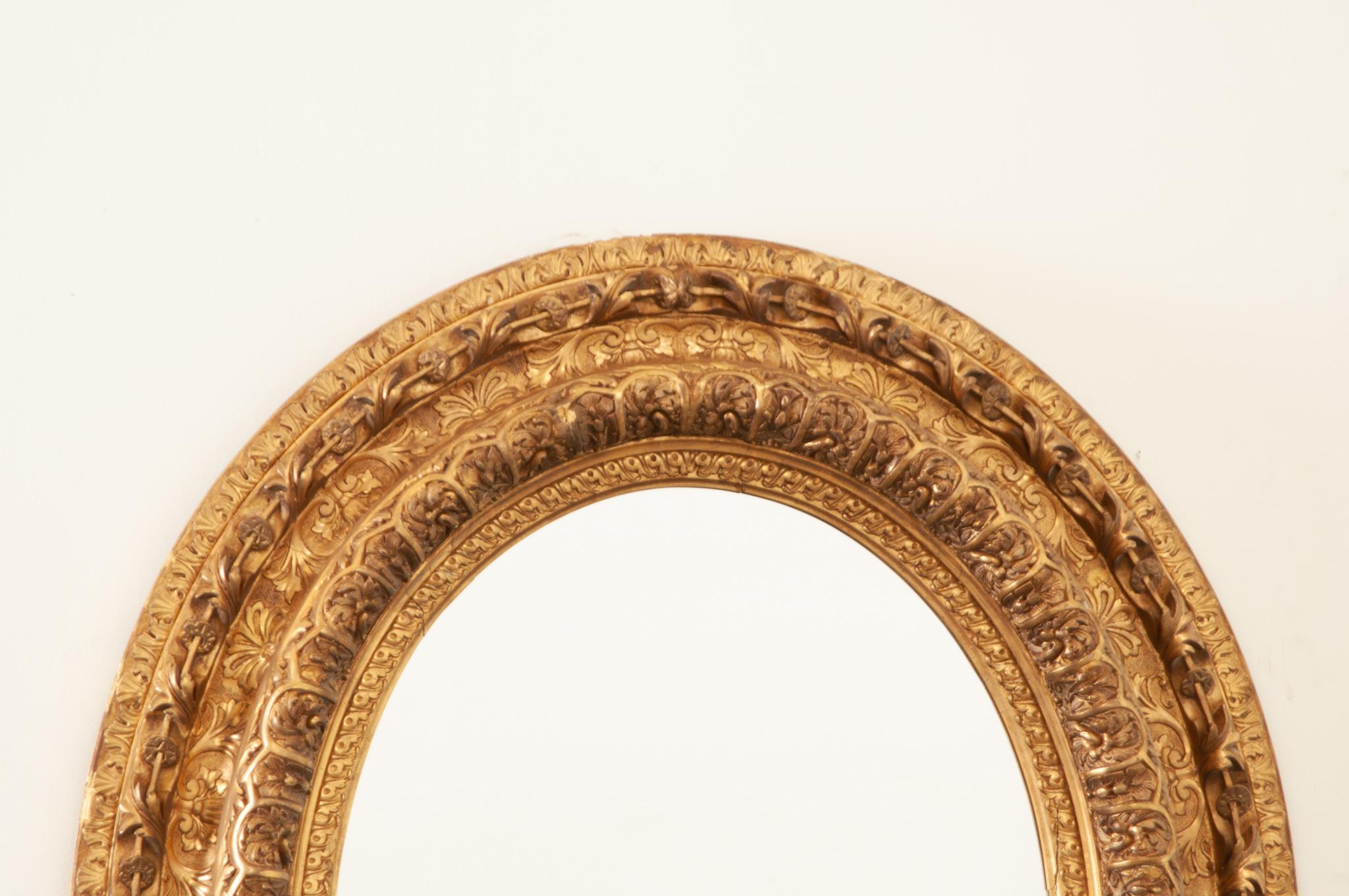 Français Miroir ovale massif en bois doré Napoléon III en vente