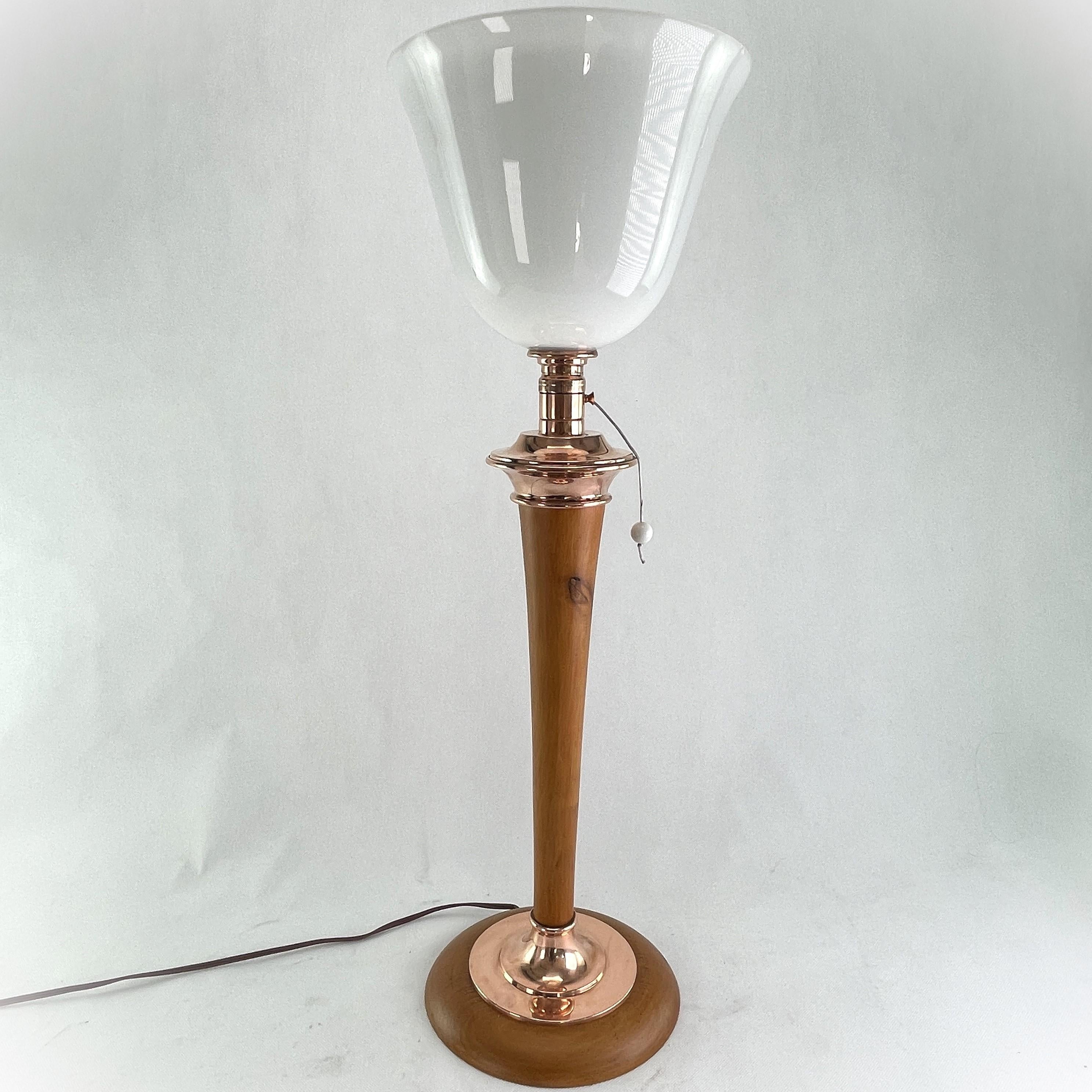 art deco MAZDA table lamp

This rare, original table lamp by the well known company MAZDA captivates with its simple and matter-of-fact Art Deco design. The base is made of wood and copper. A pull switch is located in the holder below the opal glass
