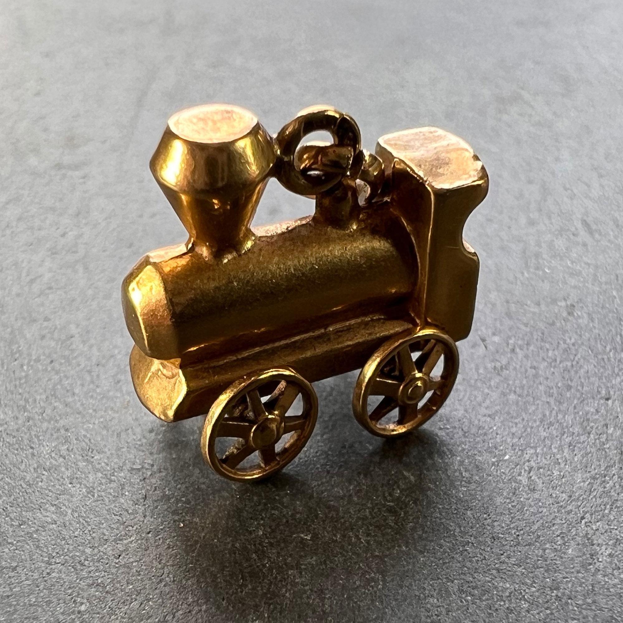 A French 18 karat (18K) yellow gold mechanical charm pendant designed as the engine of a steam train with moving wheels. Stamped with the eagle's head for French manufacture and 18 karat gold with an unknown maker's mark.

Dimensions: 1.3 x 1.3 x
