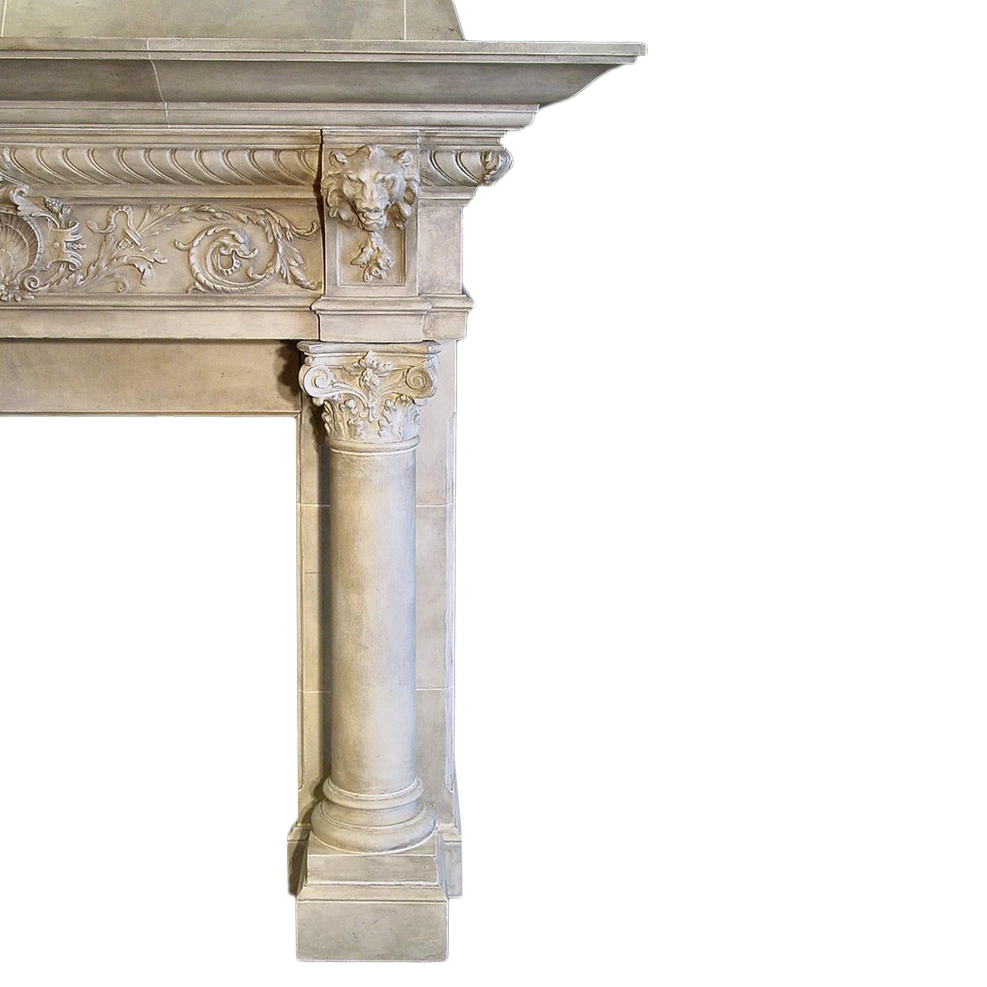 An important French 19th century Medieval st. patinated mantel with faux limestone finish. The mantel has two circular columns with impressive plaster capitals. The façade has richly carved lion heads with a central reserve of a shell amidst floral
