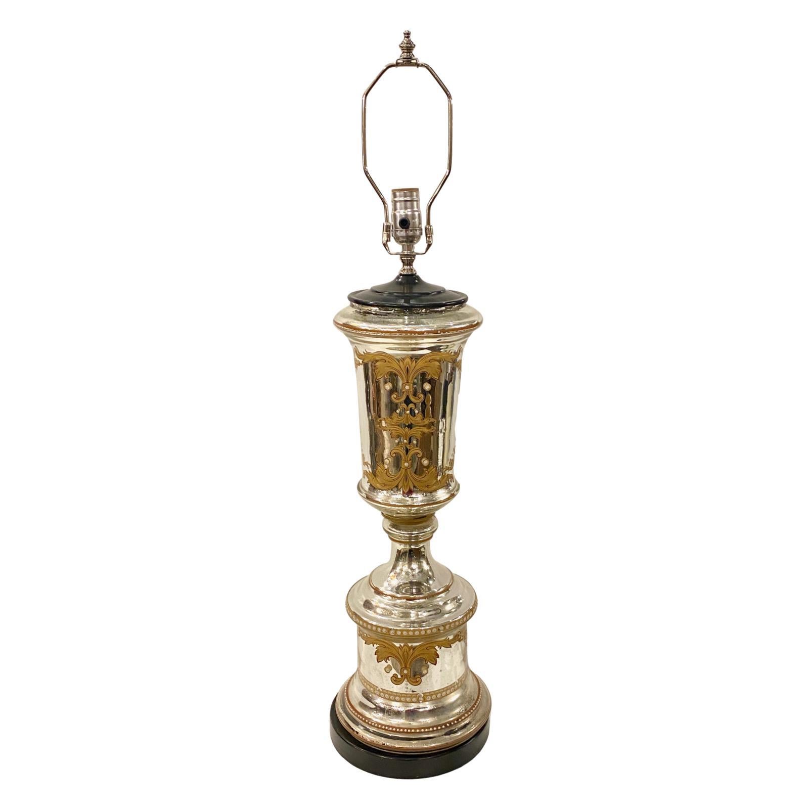 A single French circa 1940s mercury glass table lamp with gilt and painted details.

Measurements:
Height of body 24